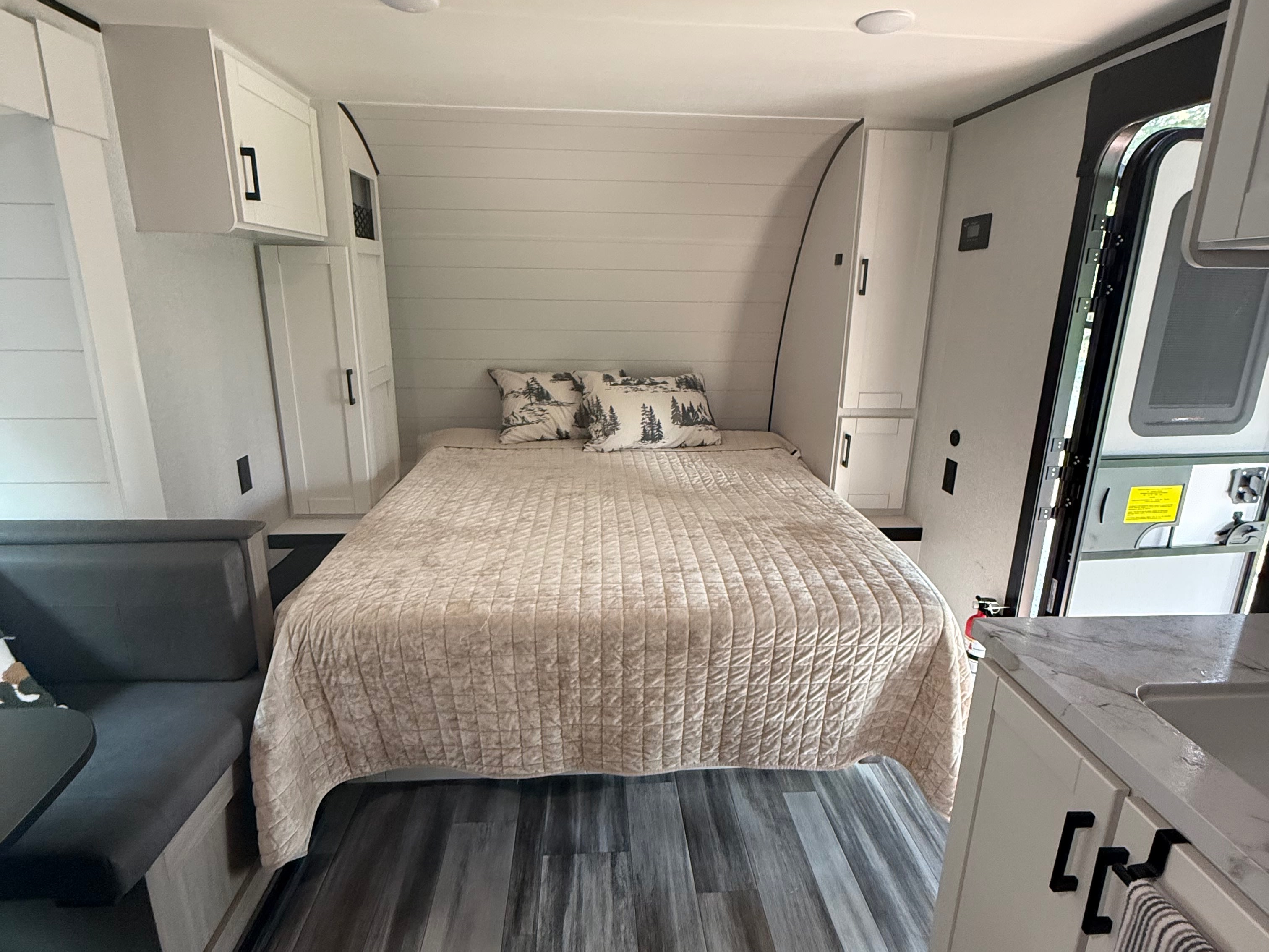Modern RV rental bedroom with shiplap walls, a cozy bed, storage cabinets, and dinette seating for travel.. Jayco Jay Flight SLX 2026
