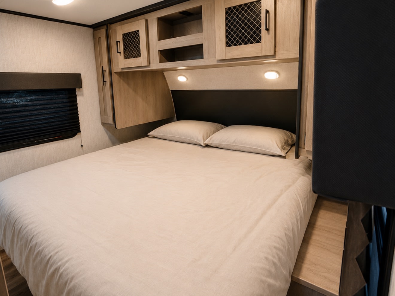 Clean RV rental bedroom with a bed, overhead cabinets, reading lights, and window blinds.. Heartland RVs Mallard 2021