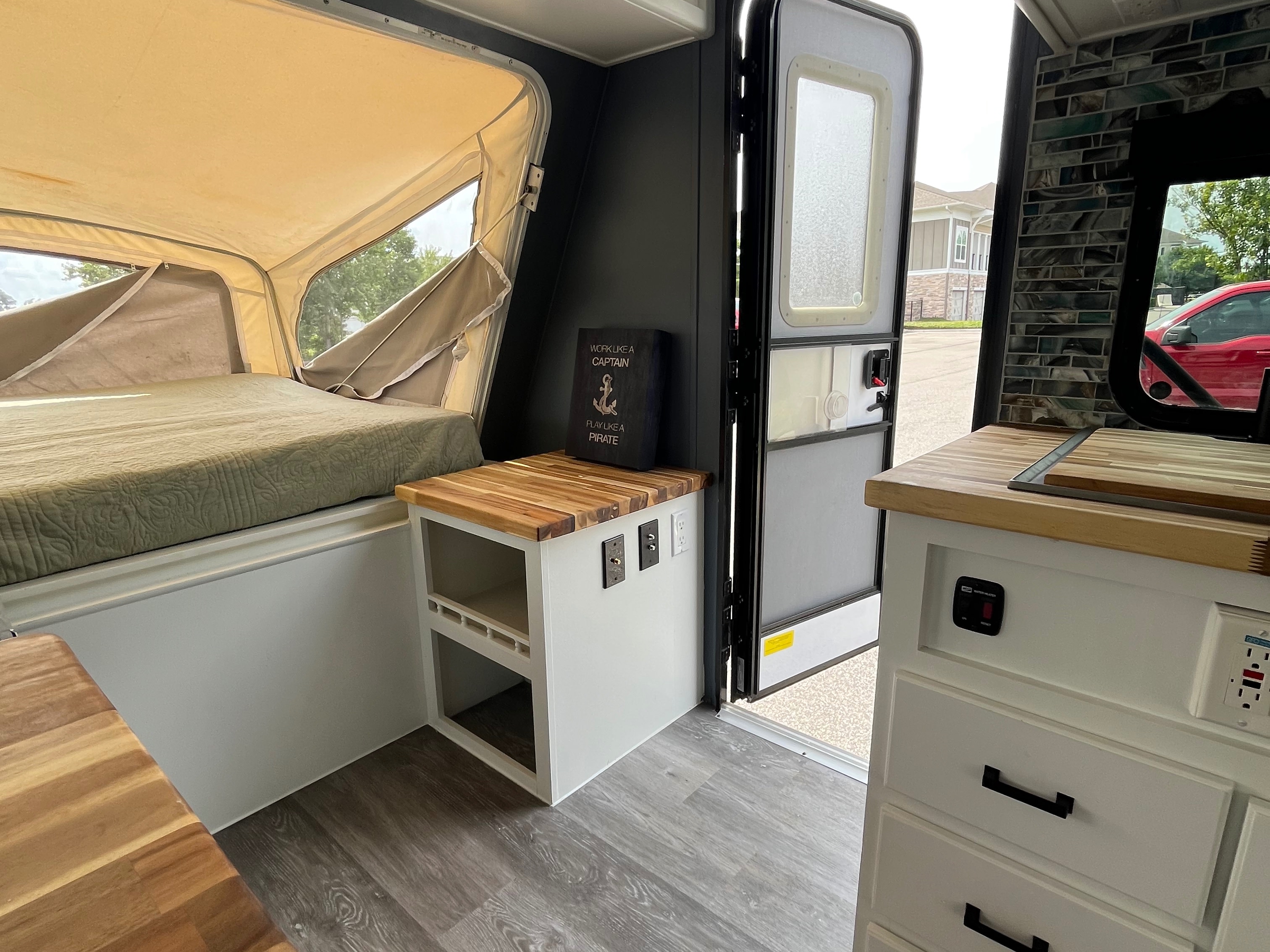 Modern RV rental interior with pop-up bed, wood countertops, and stylish decor. Perfect for your next adventure.. Forest River Surveyor Sport 2013
