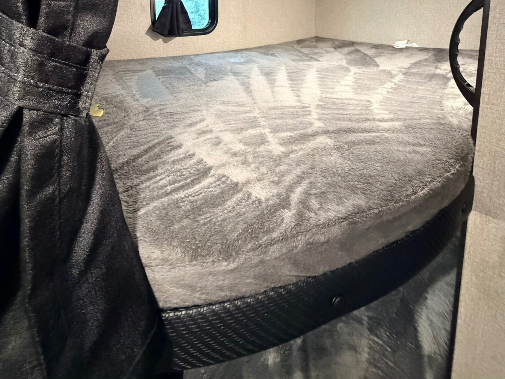 Cozy RV rental bunk bed with a grey blanket and privacy curtain, ready for rest after your travels.. Jayco Jay Flight SLX 2022