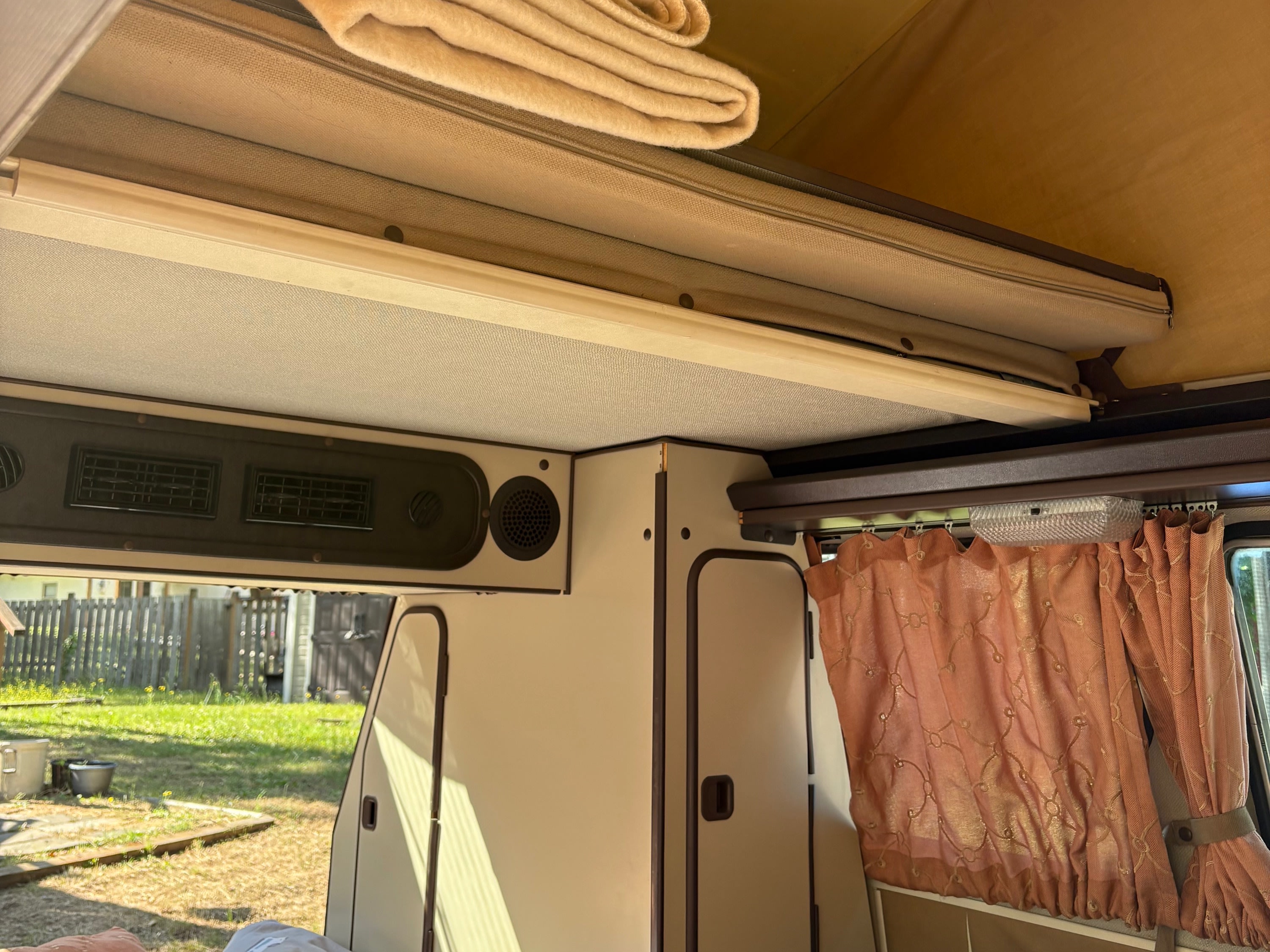 Inside an RV rental: a comfortable sleeping area, overhead storage with blankets, and functional cabinets. Ready for travel.. Westfalia T3 Westfalia 1986