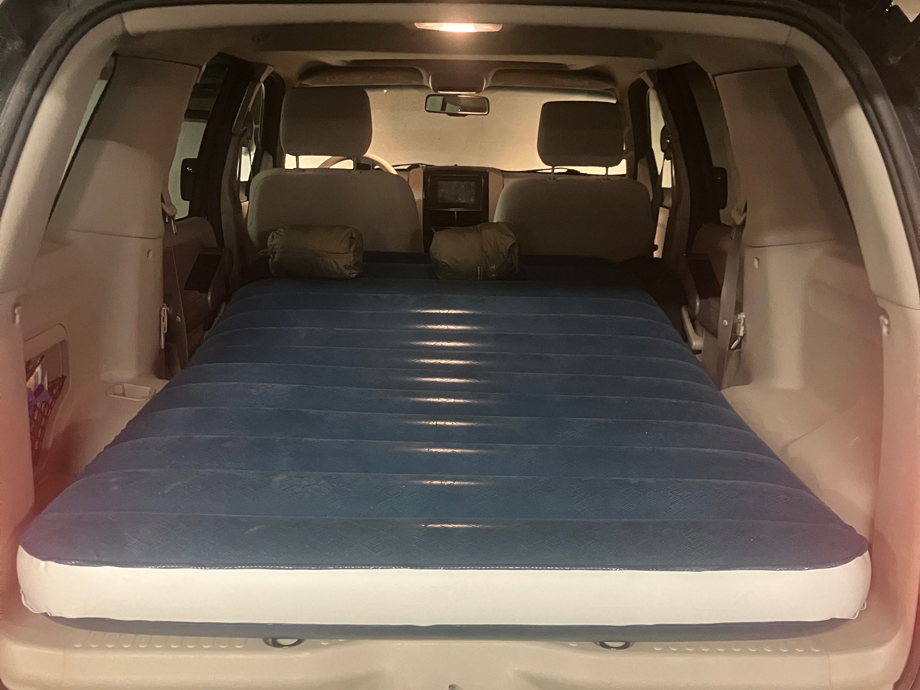 Comfortable car camping setup in an SUV features an air mattress. An ideal rv rental alternative for a road trip or overnight stay.. Ford Explorer XLT 2006