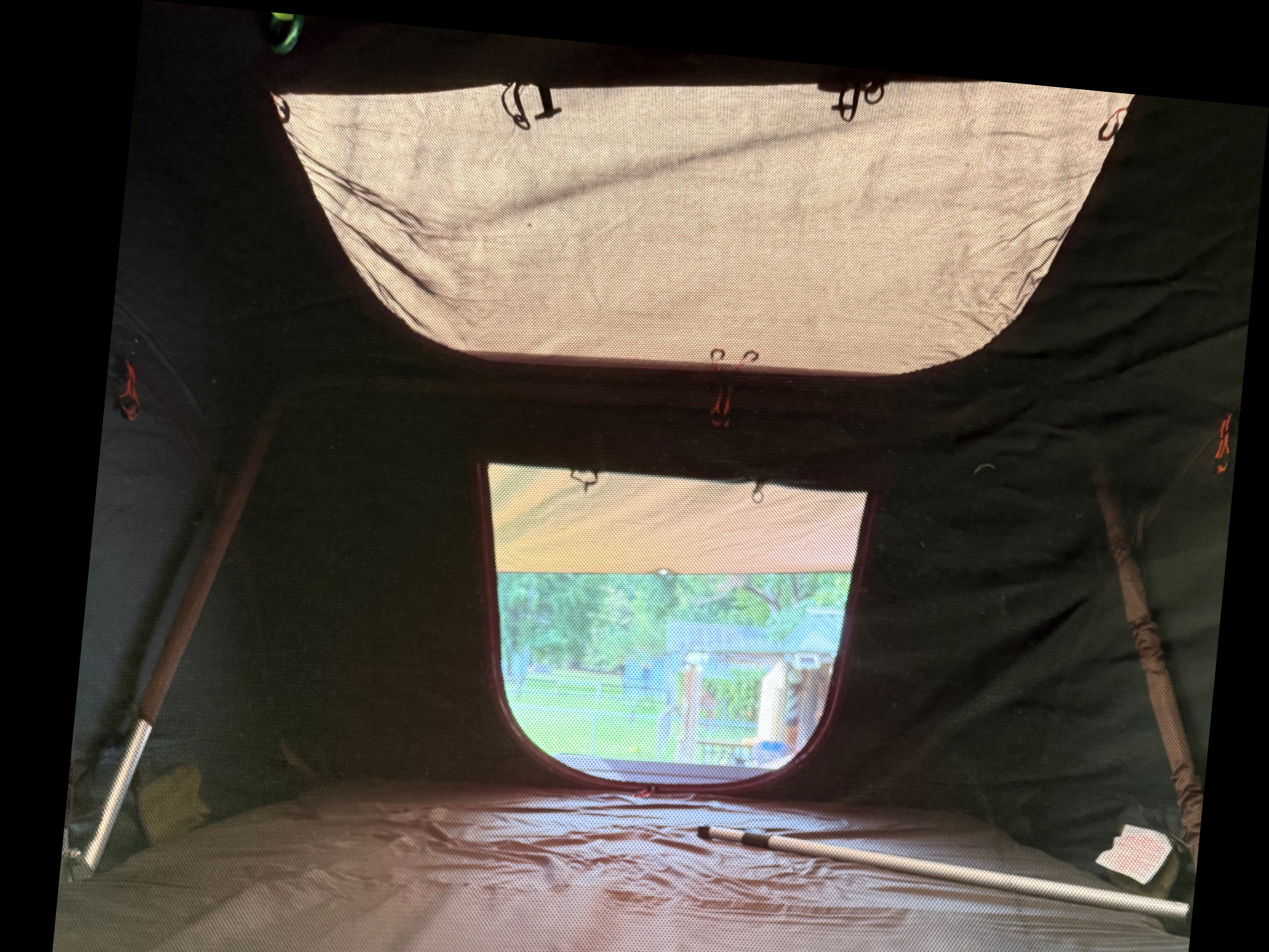 Inside a camping tent, often part of an RV rental trip, featuring a large mesh top & window looking out to a backyard.. No Boundaries 10 2018