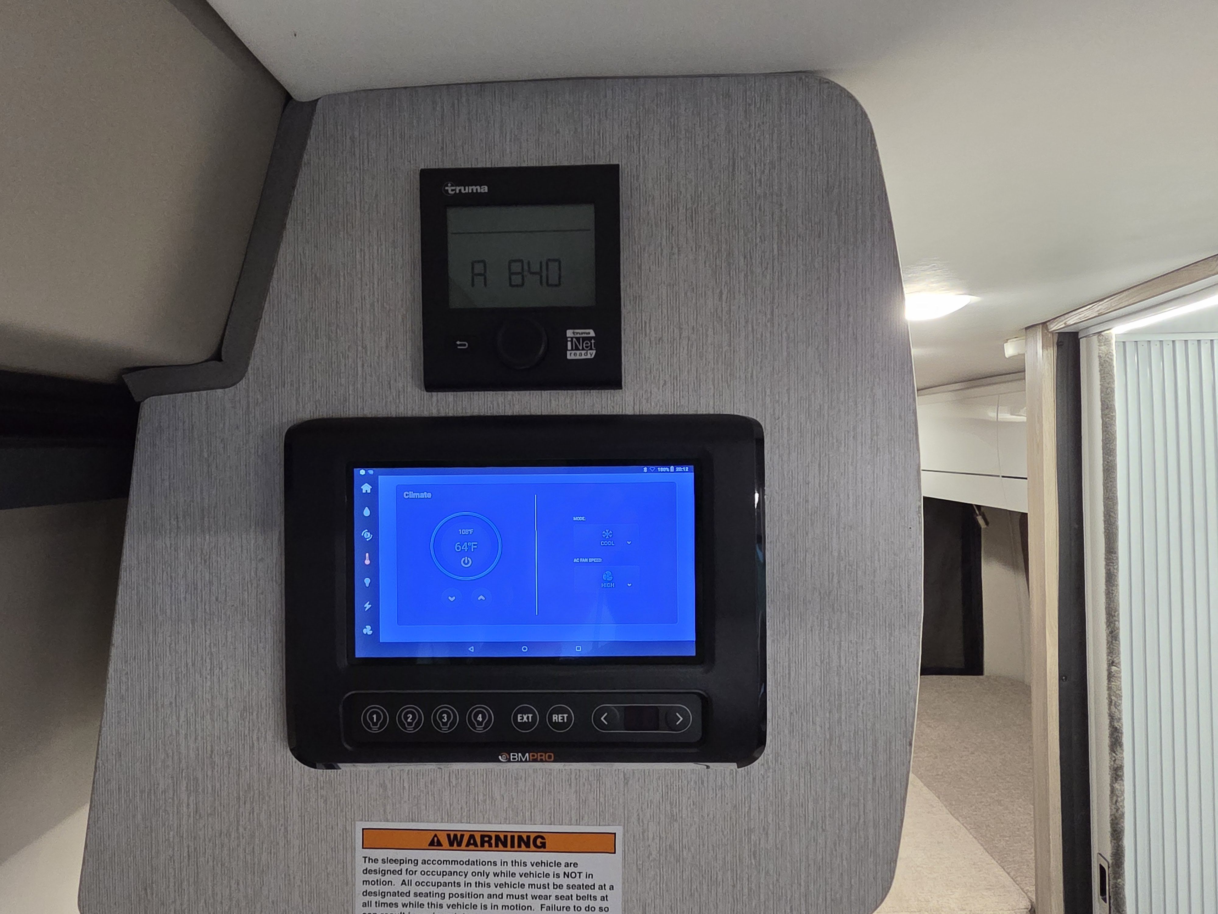 RV rental's interior showing its climate control panel (Truma, BMPRO) with settings and a safety warning.. Thor Tellaro 2022