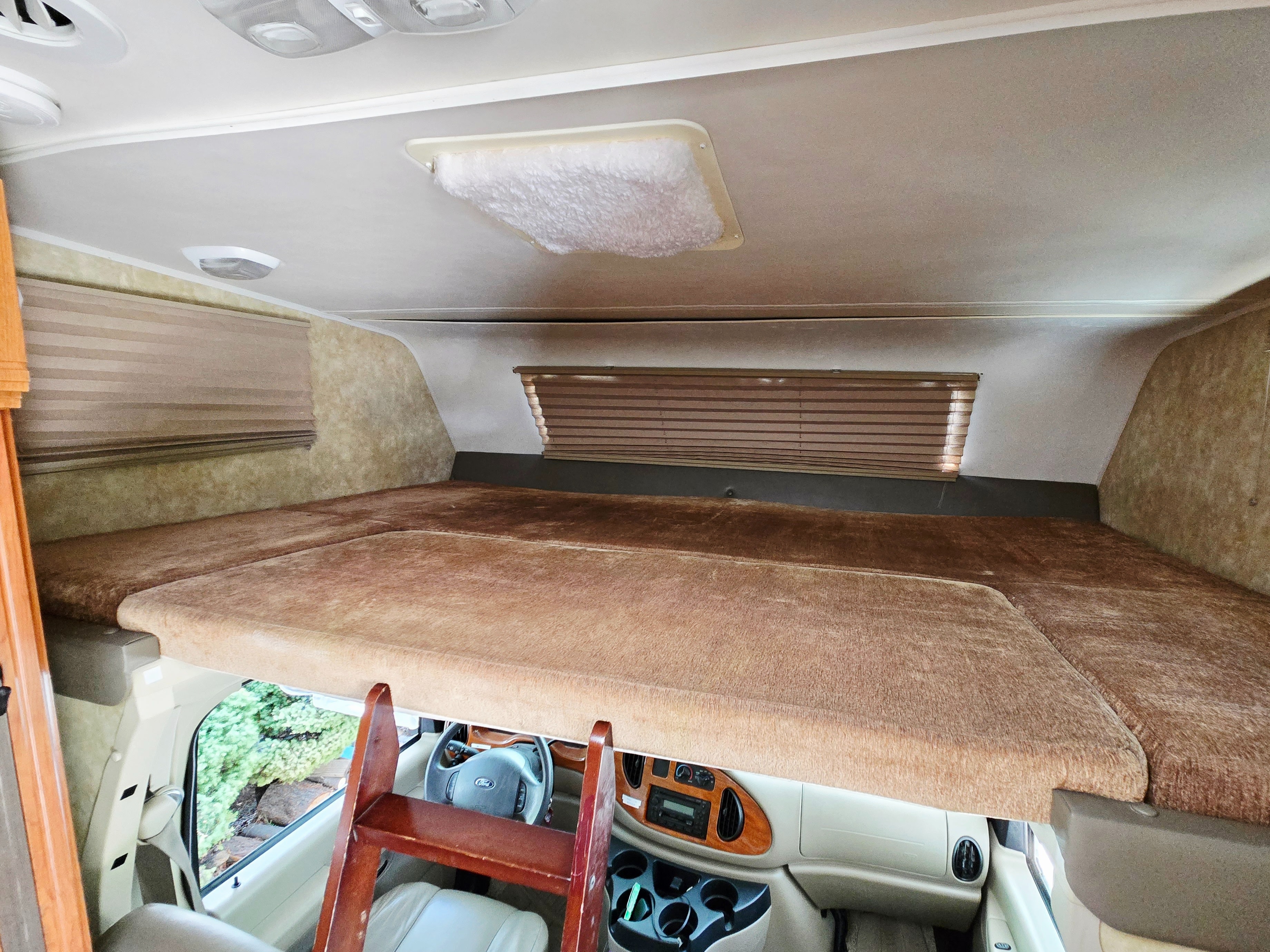 Spacious cab-over sleeping bunk in this RV rental, with a ladder & driver's area below.. Coachmen Freedom Express 2008
