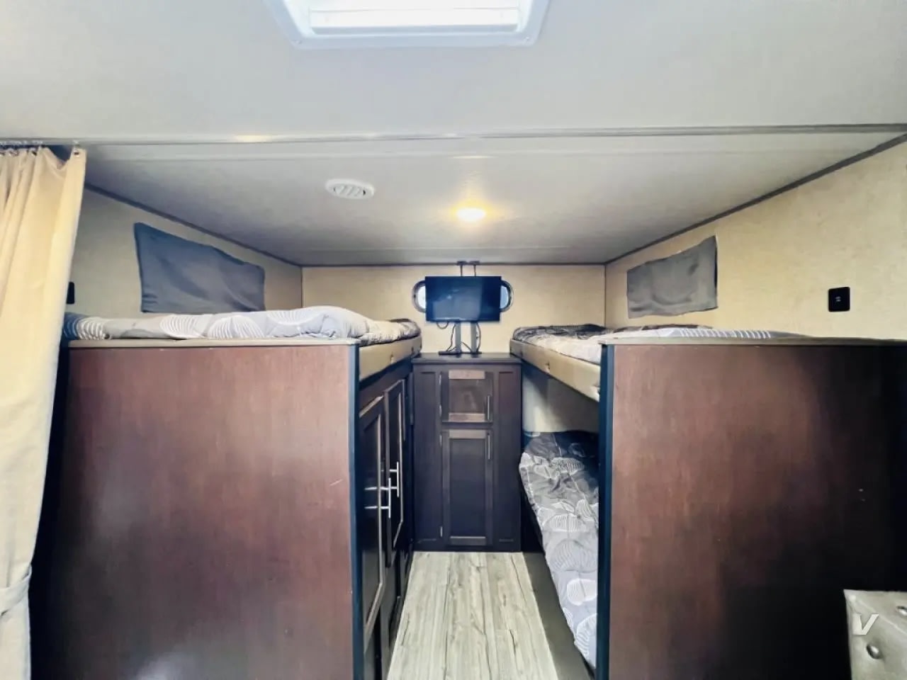 RV rental interior features cozy bunk beds, TV, storage, and natural light from the skylight, great for travel.. Forest River Cherokee Grey Wolf 2019