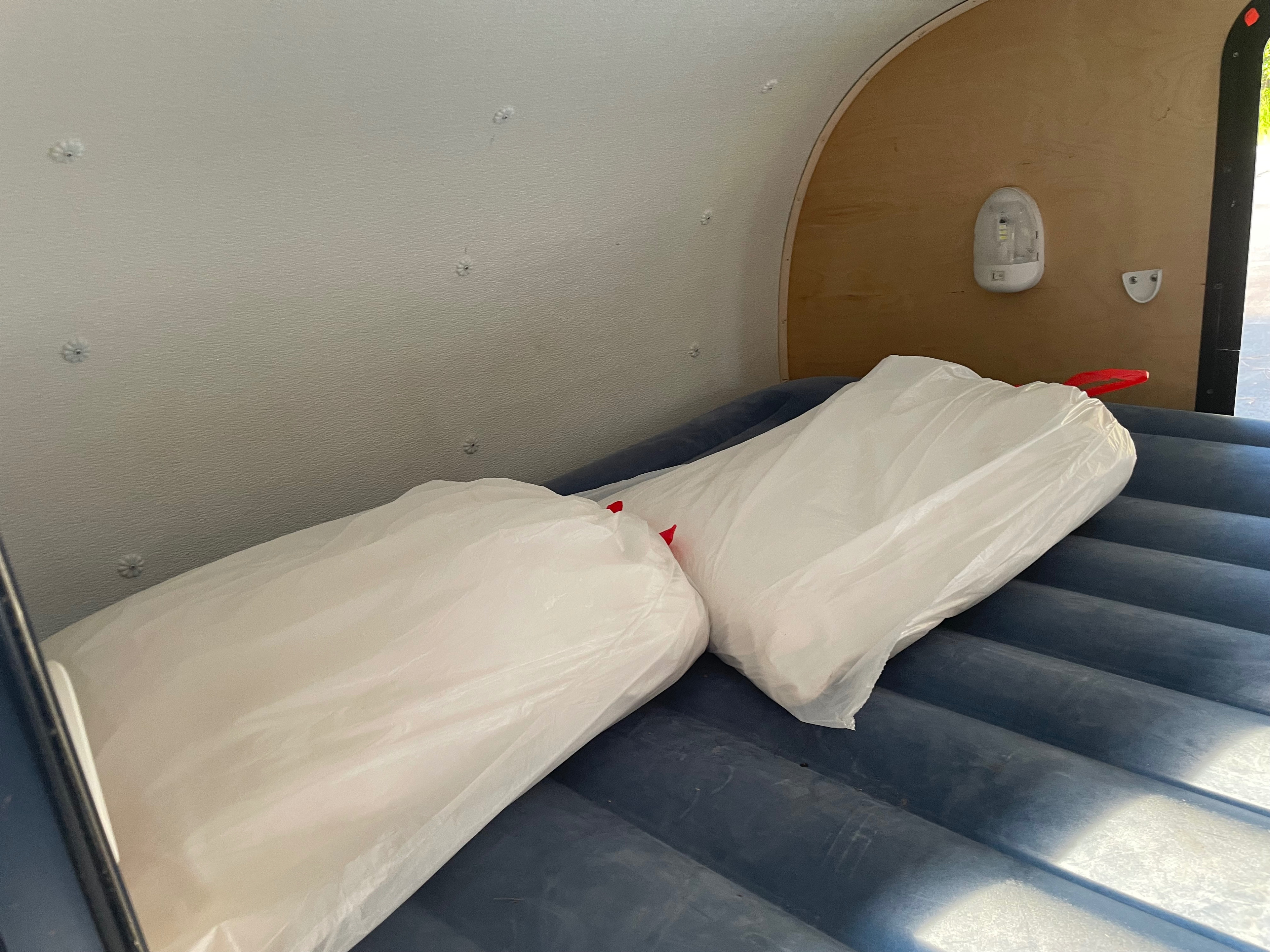 Cozy RV rental sleeping area with an inflatable air mattress & white-wrapped pillows, ready for travel.. hand built teardrop 2016