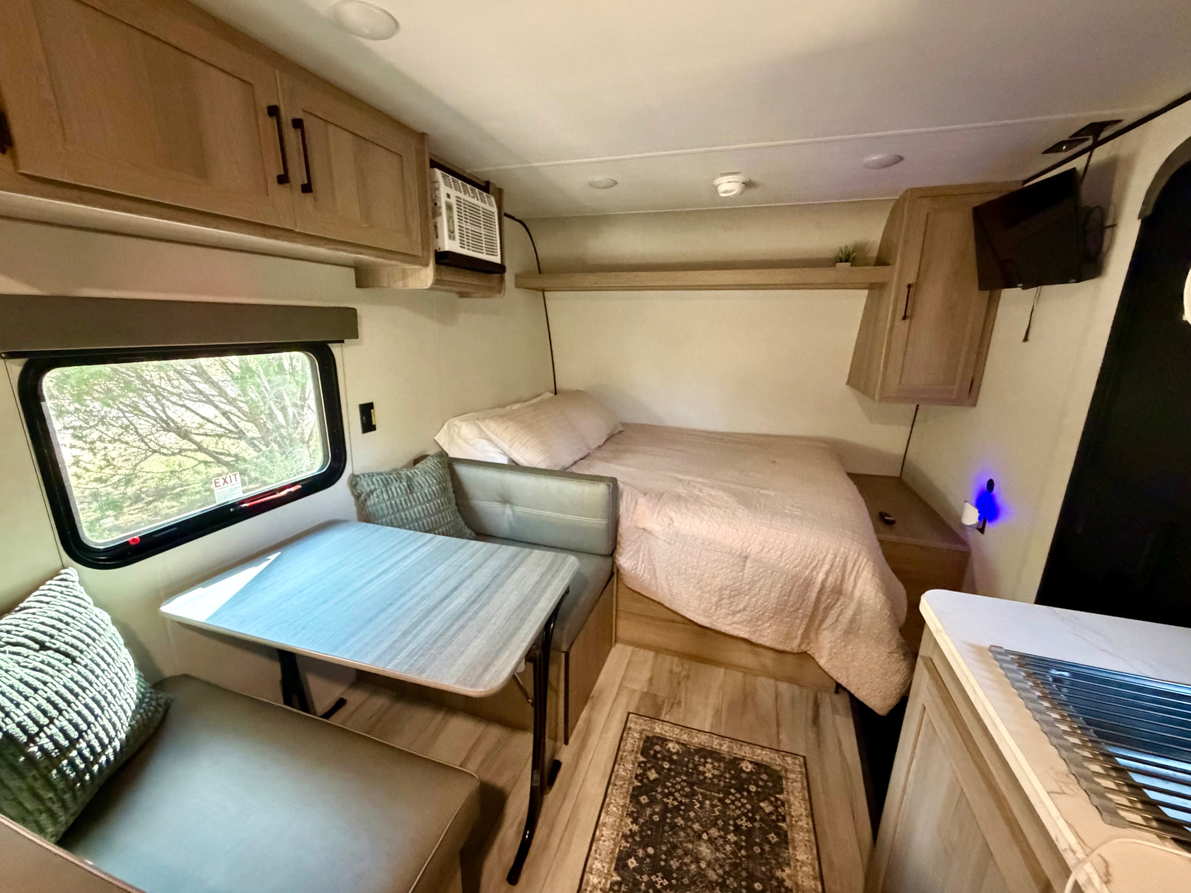 Cozy rv rental interior featuring a bed, dinette, and compact kitchen. Ideal for a comfortable travel experience.. Keystone RV Coleman 2026