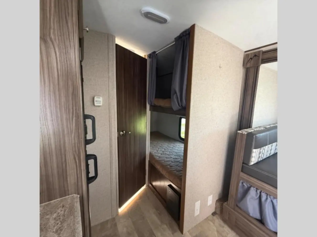 This rv rental camper interior features bunk beds, a seating area, and wood finishes, great for family trips.. Coachmen Apex Nano 2018