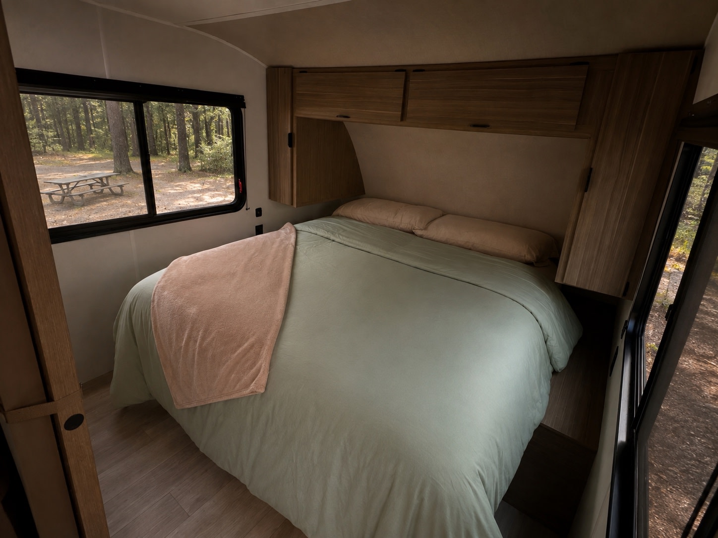 Cozy RV rental bedroom with a view of the peaceful campsite. Perfect for your next adventure!. Forest River RV EVO 266BHLE 2026