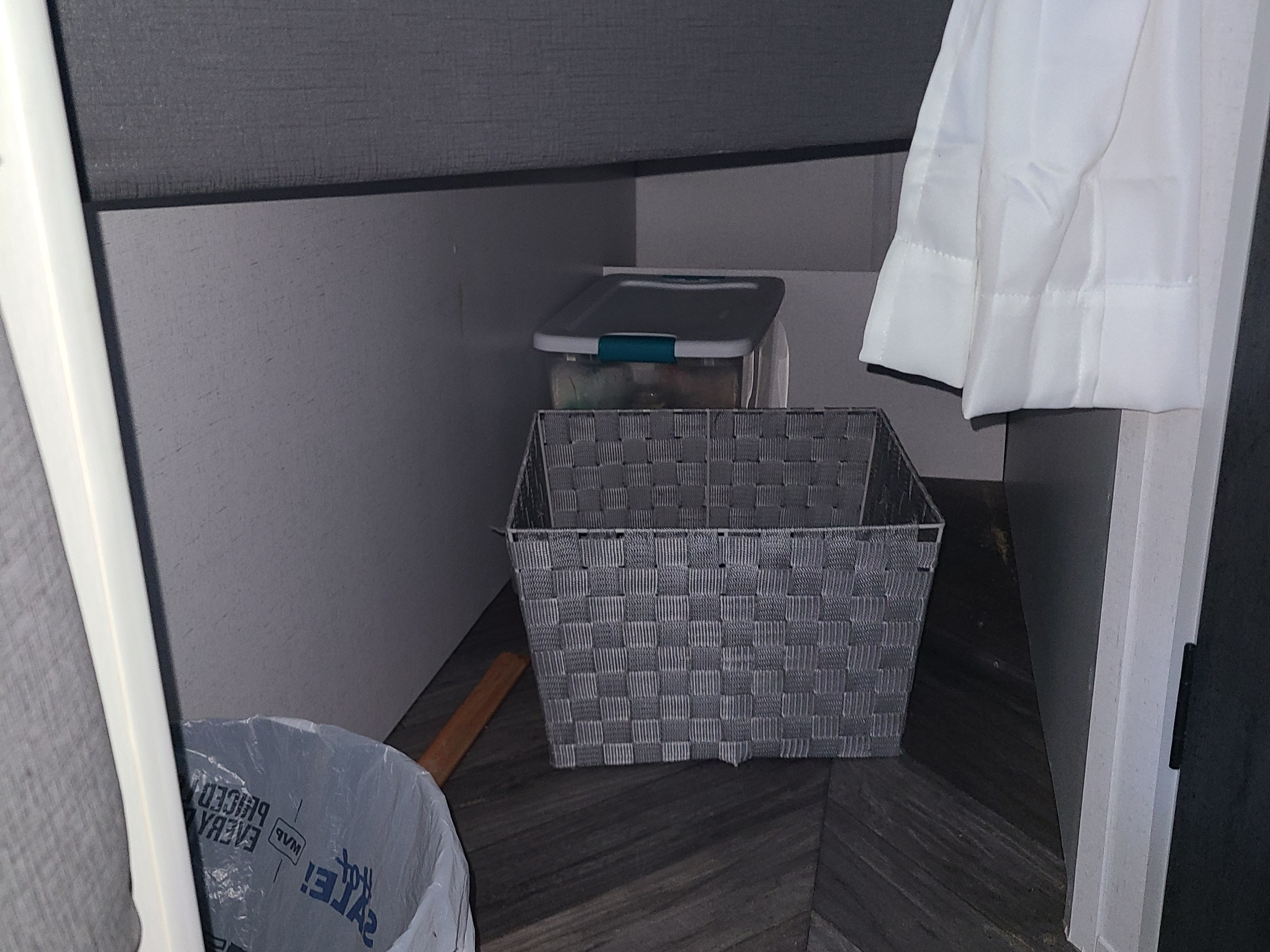 RV rental under-bed storage: a woven basket, plastic bin, and trash bag organized in a compact interior space.. Forest River Salem FSX 2019