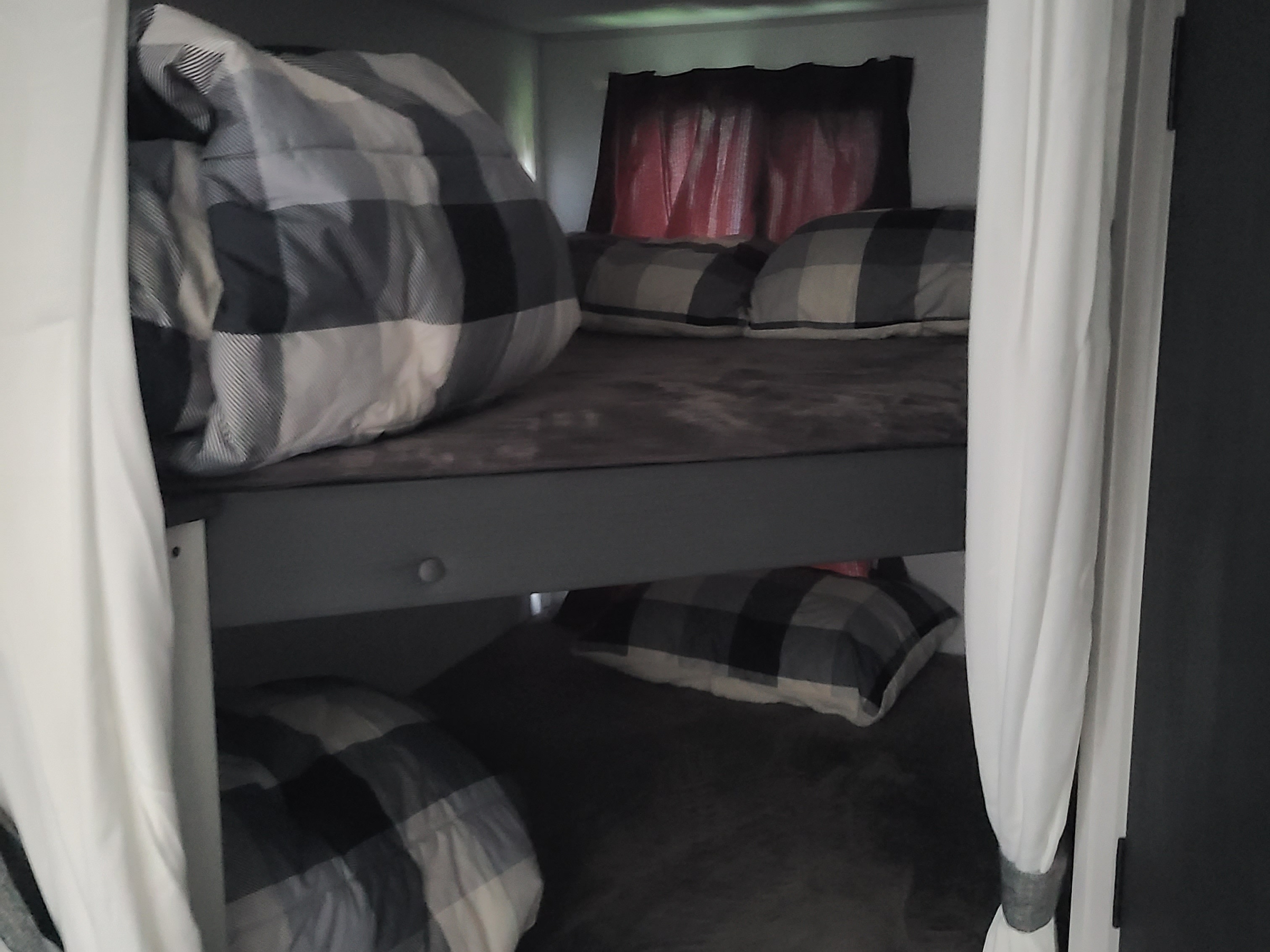 Cozy RV rental bunk beds with buffalo plaid bedding and privacy curtains, perfect for a family adventure.. Forest River Salem FSX 2019