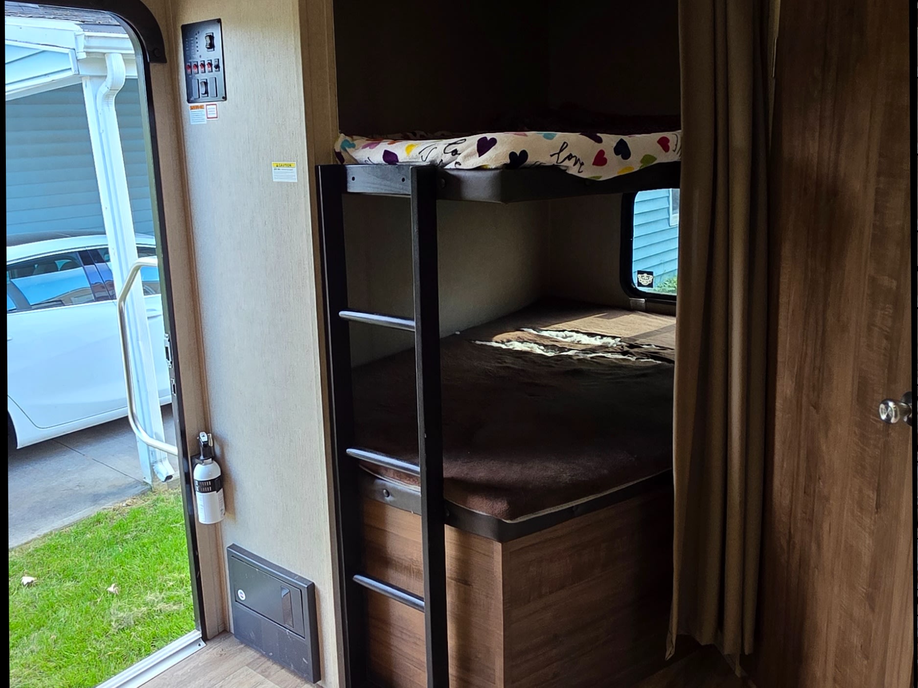 RV rental interior featuring cozy bunk beds, a control panel, and a fire extinguisher. Perfect for family trips.. Dutchmen Aspen trail 2018