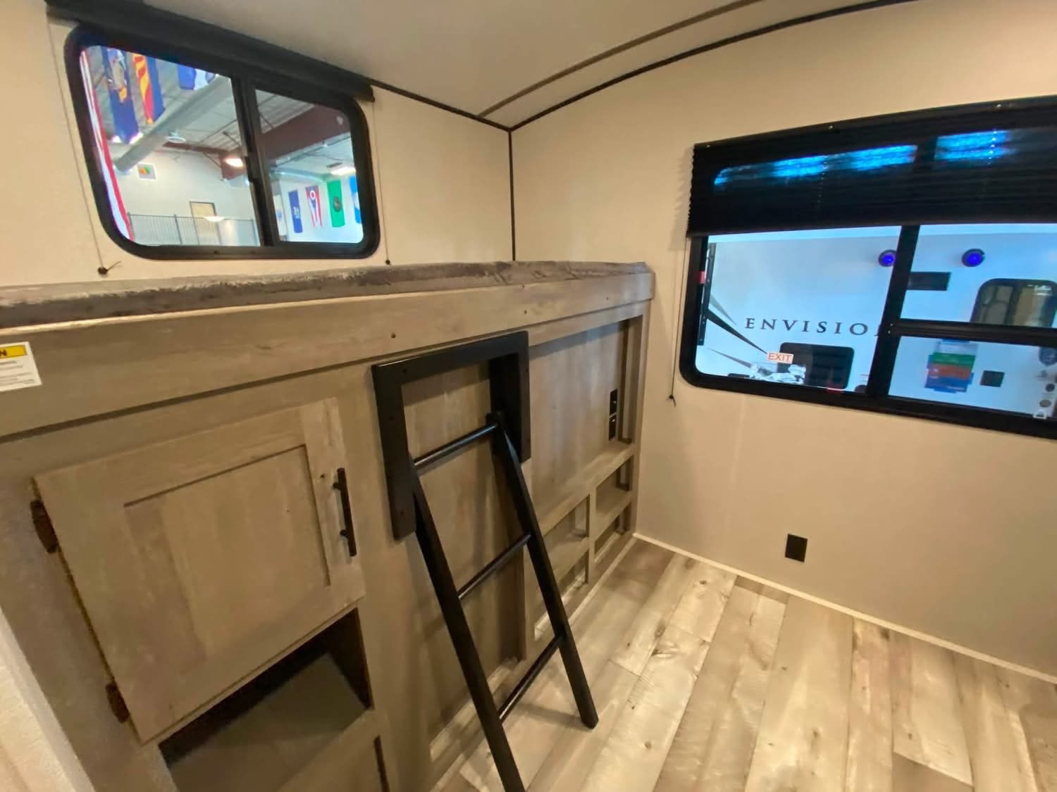 RV rental interior features bunk beds with a ladder, storage, and windows, ideal for family travel adventures.. Keystone RV Springdale 2021
