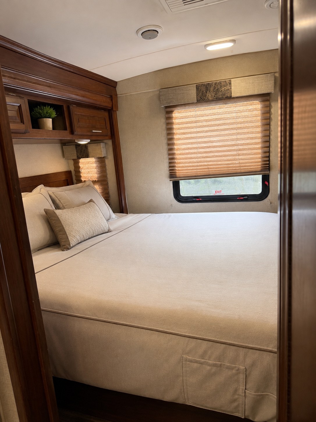 Comfortable RV rental bedroom with a large bed, pillows, wooden cabinets, and window for a restful journey.. FR3 FR3 Motorhome 2018