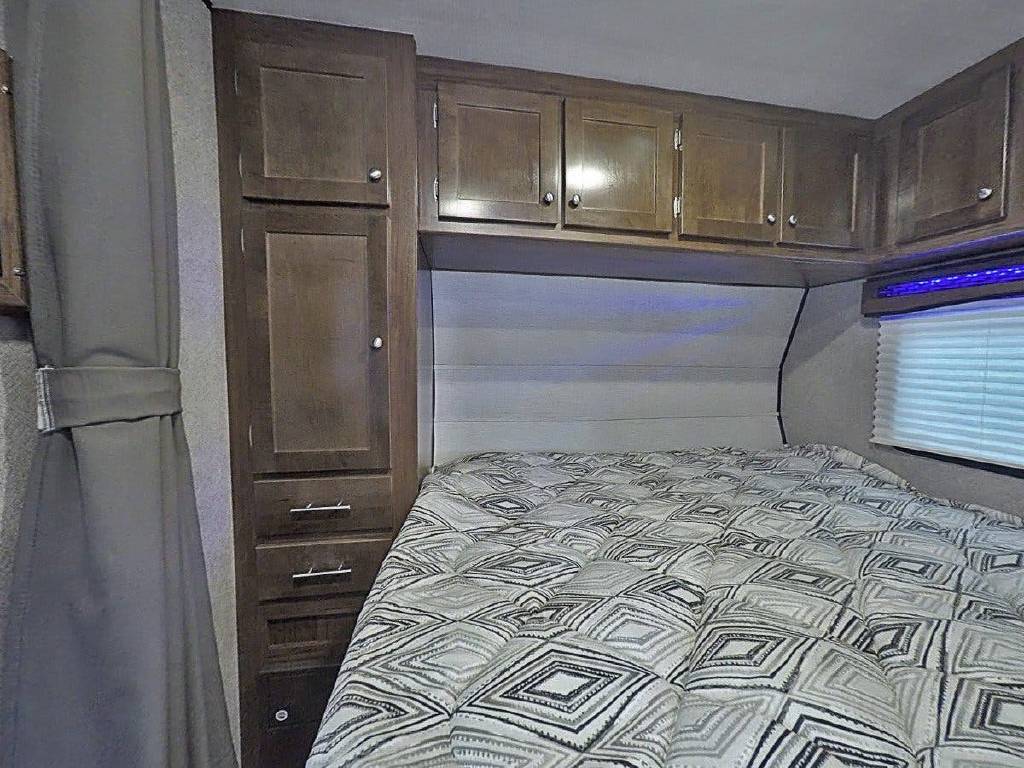 RV rental bedroom: Cozy interior with bed, storage cabinets, & window. Ideal for comfortable travel.. Heartland RVs Terry Classic 2019