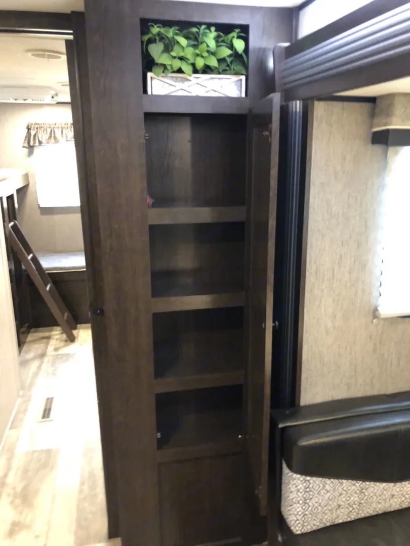 RV rental: Dark wood pantry with open shelves, a plant above, and glimpses of bunk beds and a living area.. Heartland RVs Prowler 2020
