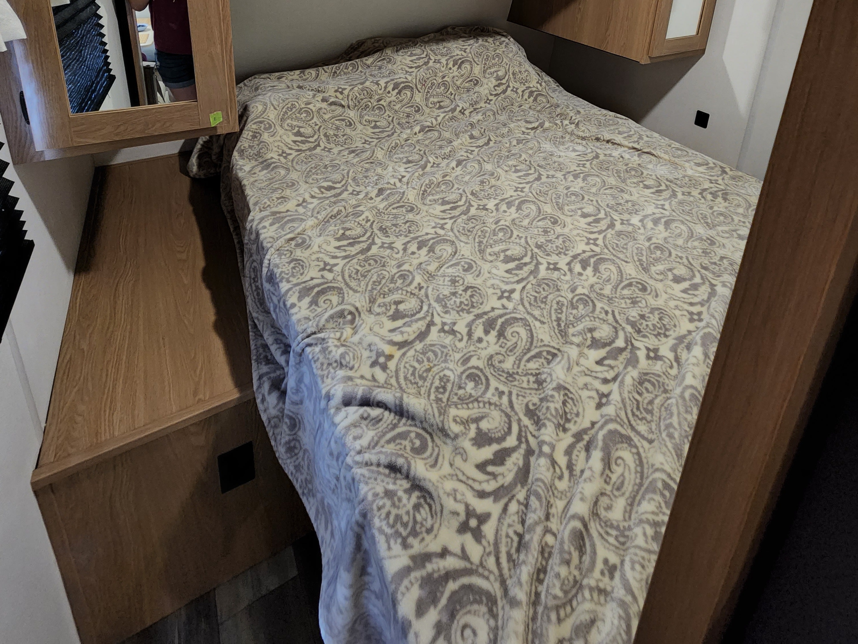 Discover this cozy RV rental bedroom: light wood cabinets, a comfy bed with a paisley comforter, and a mirror.. Avenger Avenger Trailer 2022