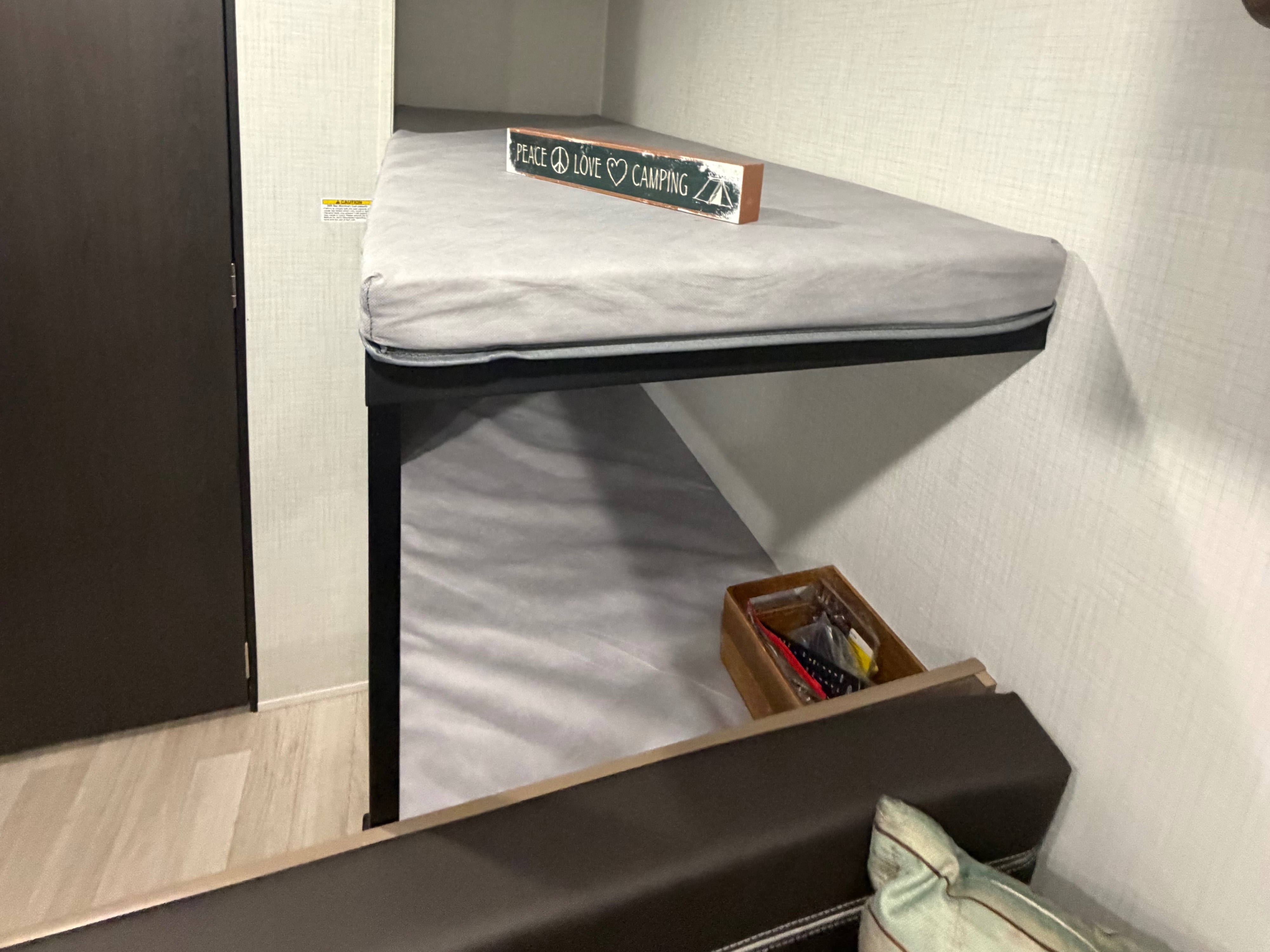 RV rental bunk beds with a 'Peace Love Camping' sign and essentials box, ready for your next adventure.. Keystone RV Springdale Mini 2026