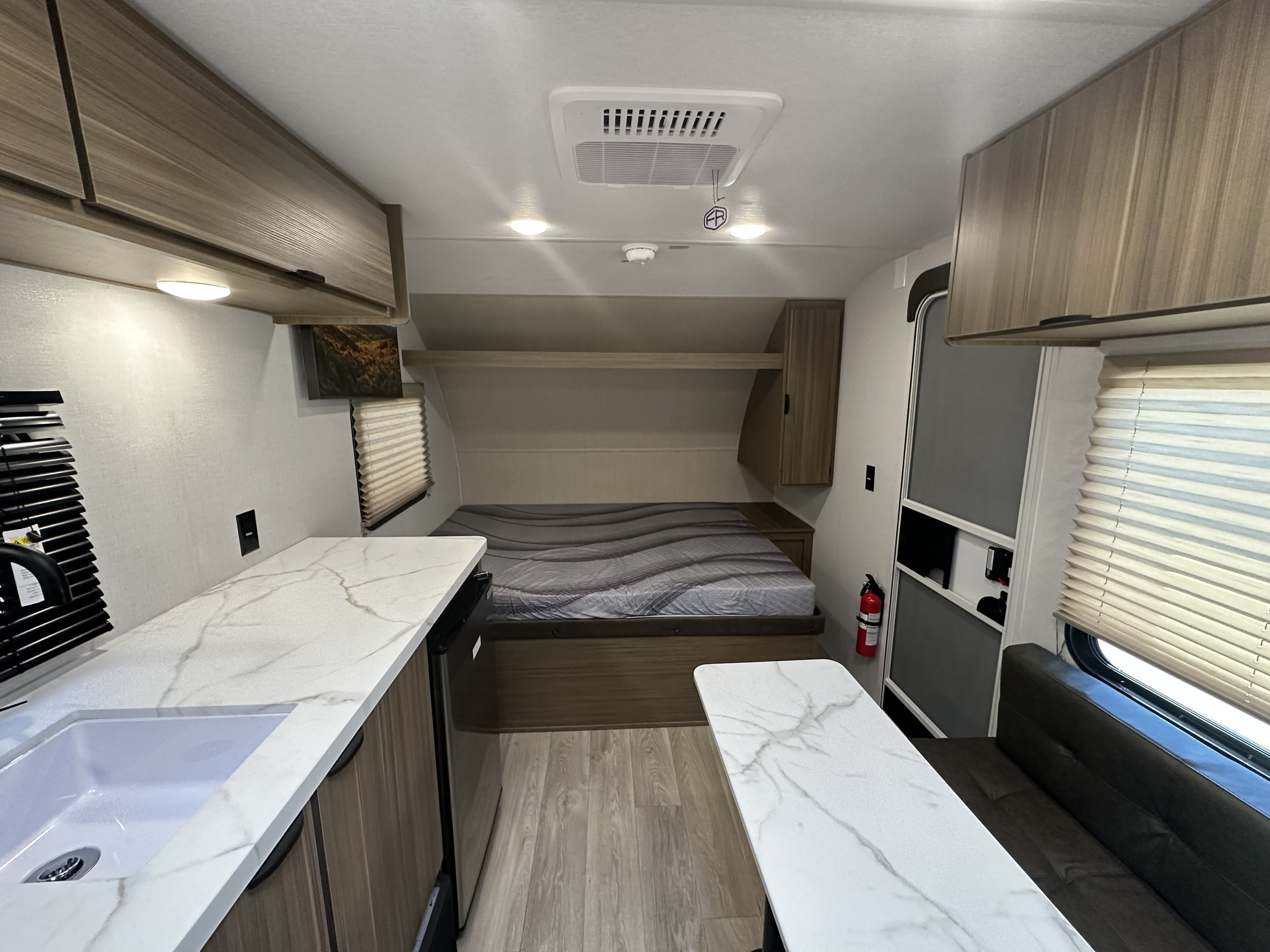 Spacious RV rental interior with a cozy bed, kitchen with sink, dining area, and ample storage for a comfortable trip.. Forest River Salem 2026