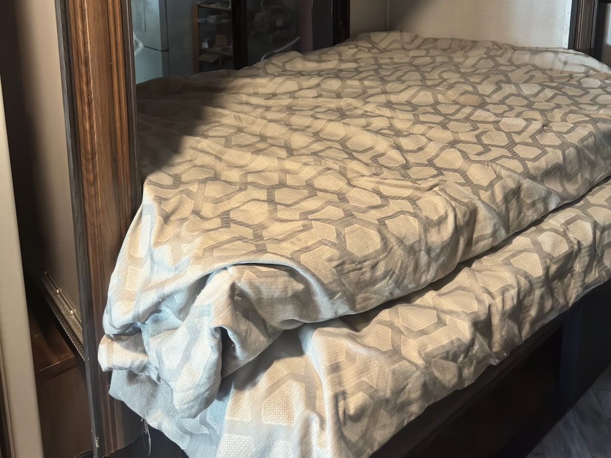 Comfortable bunk bed in an RV rental, featuring a gray patterned comforter. Perfect sleeping space for your trip.. Forest River Sunseeker LE 2022