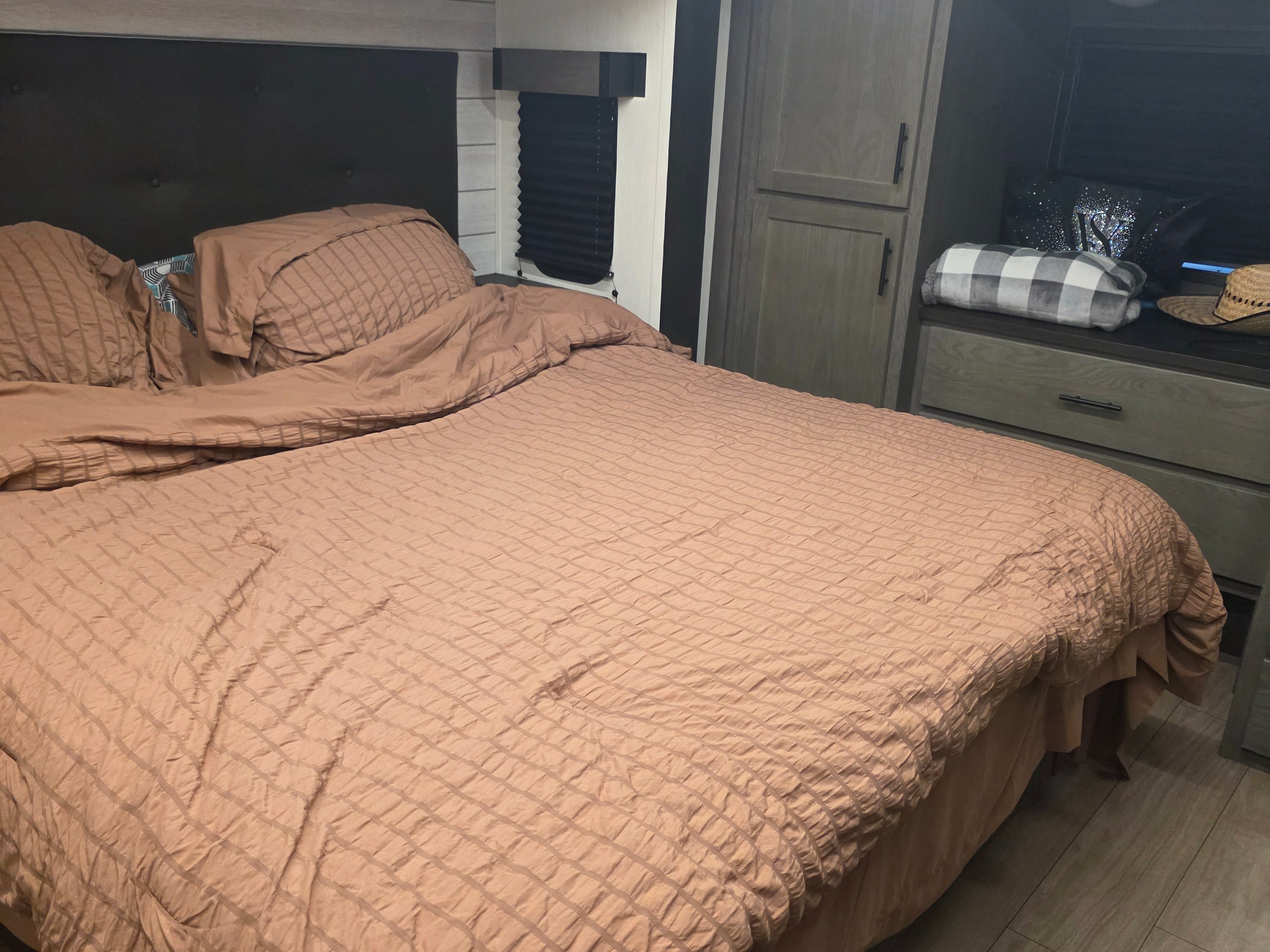 Cozy RV rental bedroom with a comfy bed, textured bedding, headboard, wardrobe, and a dresser.. Forest River Cherokee Alpha Wolf 2026