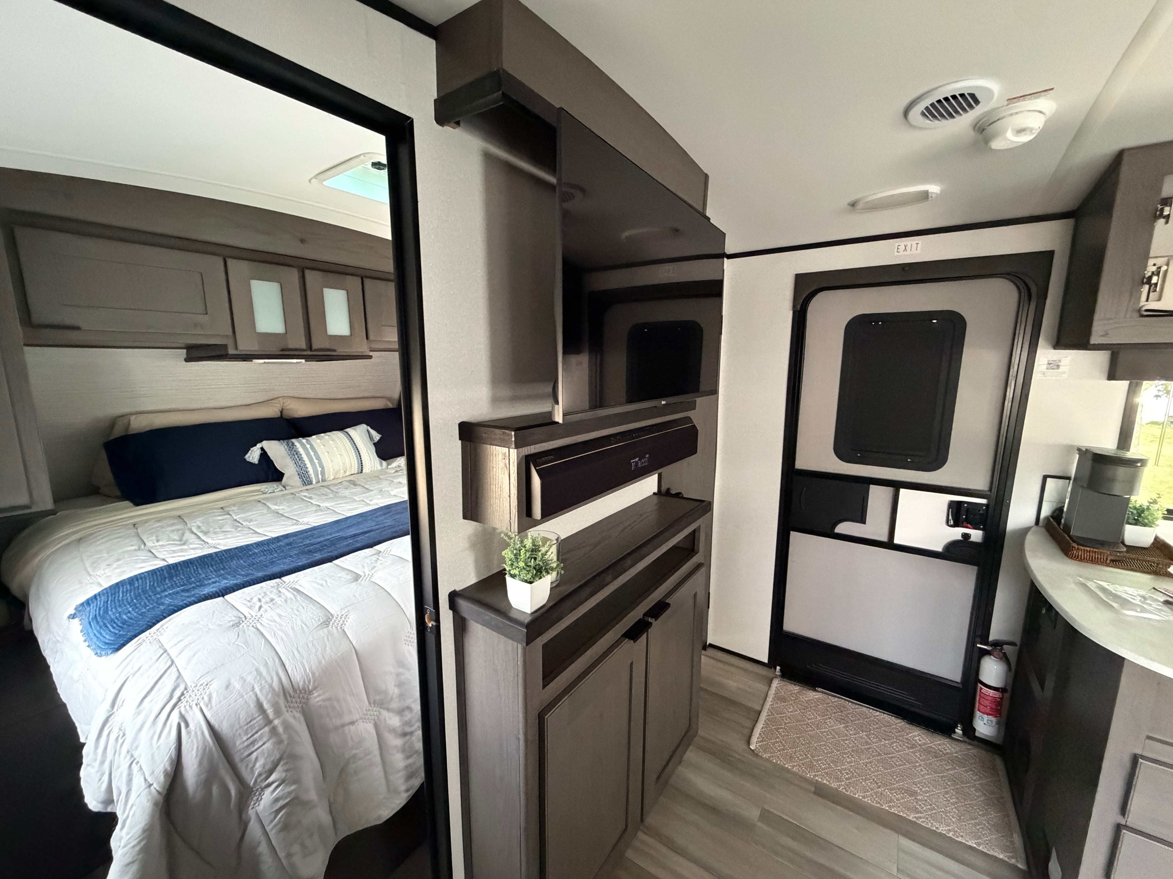 Explore this modern rv rental interior, showcasing a cozy bedroom, living area with TV, and essential safety features.. Cruiser RV MPG Ultra Lite 2022