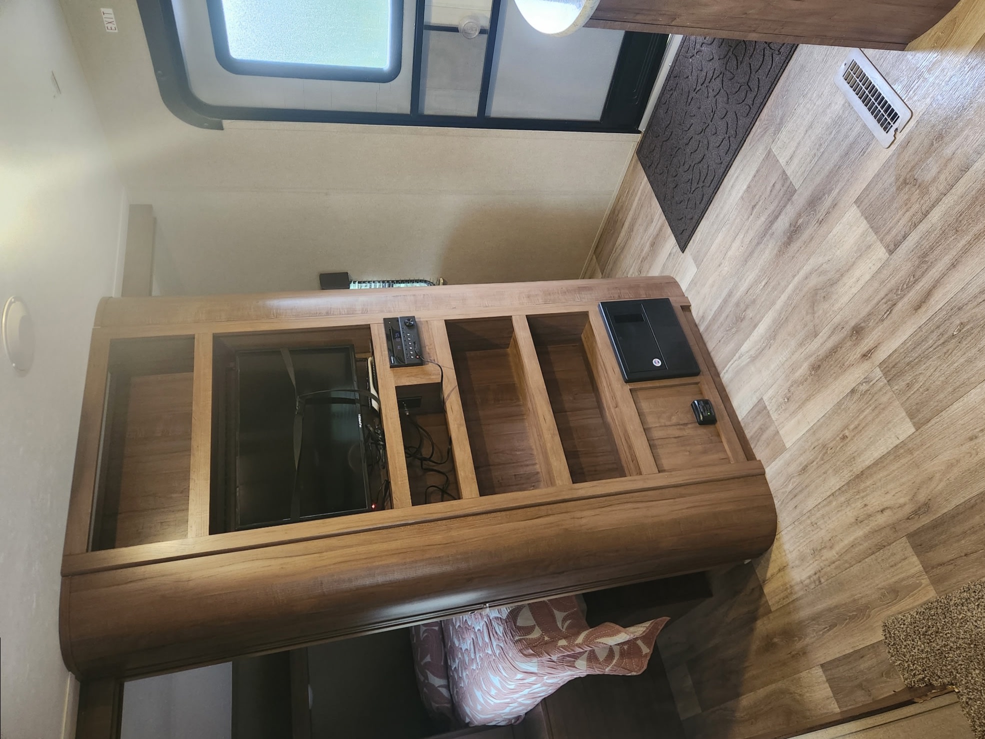 RV rental interior. View of a wood entertainment unit with TV, stereo, and shelving. Light wood-look floor, skylight overhead.. Aspen Trail Aspen Trail Trailer 2018