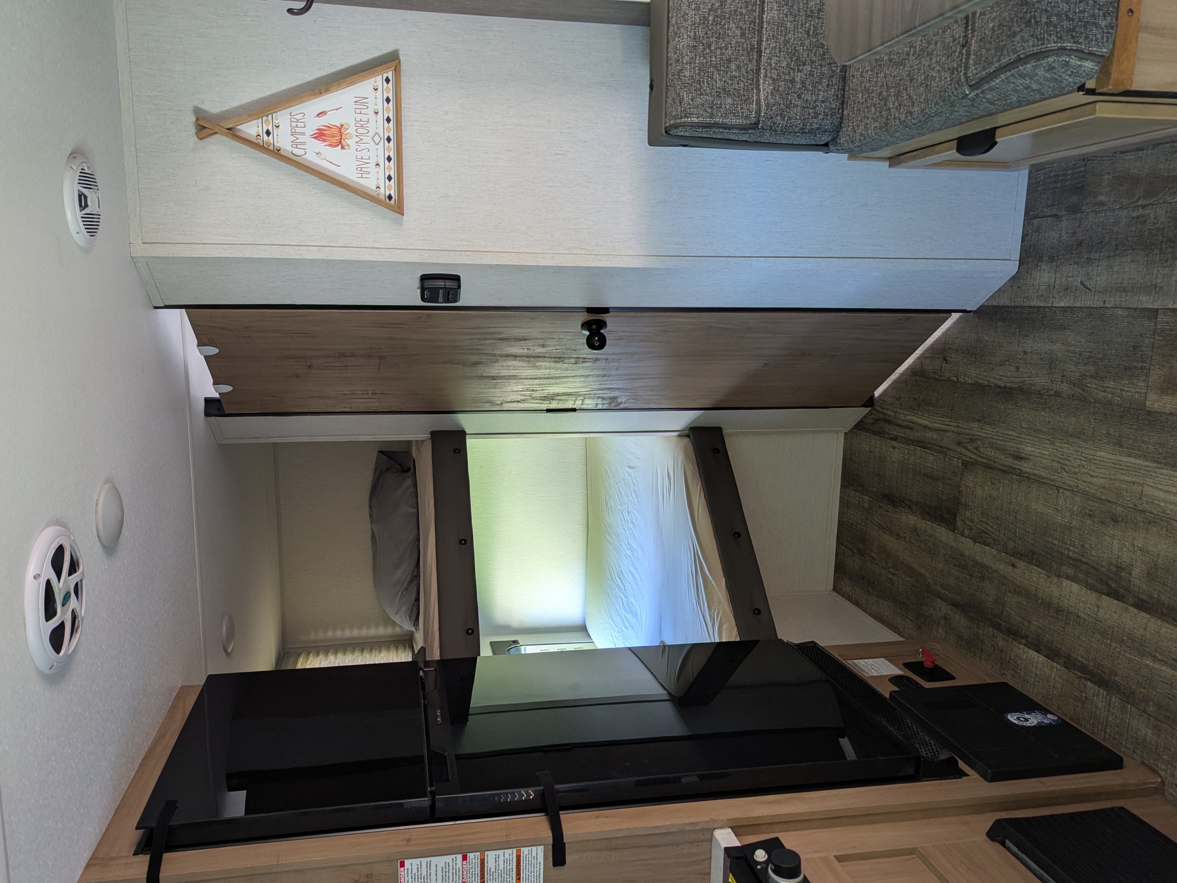 RV rental interior featuring a bunk bed area, kitchen counter, dinette seating, and safety devices, ready for a cozy camper trip.. Forest River Cherokee Wolf Pup 2024
