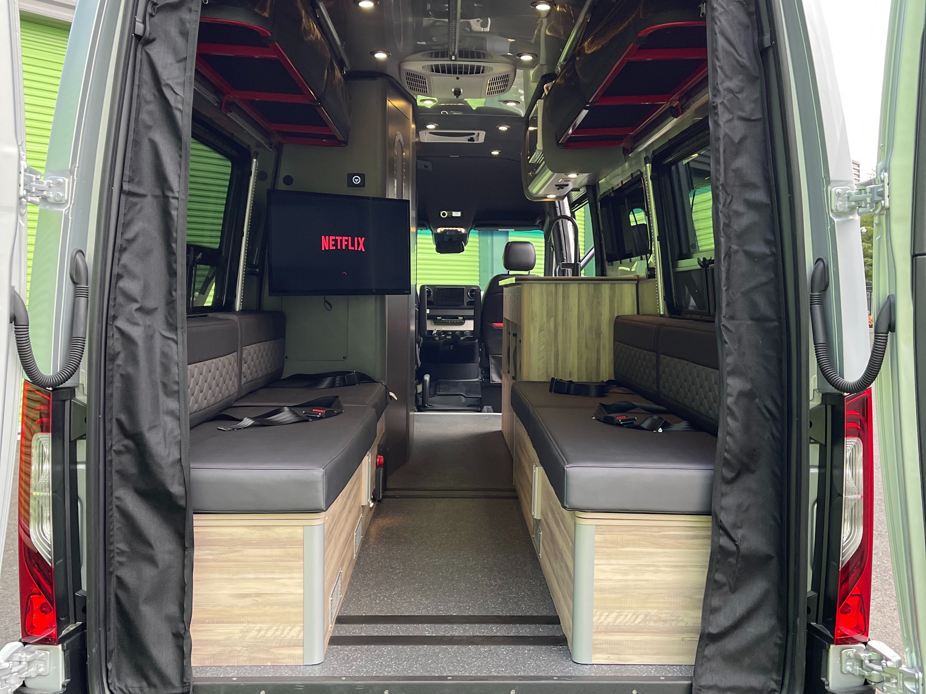 This RV rental interior features comfortable seating that converts to beds, a TV with Netflix, and a kitchenette, perfect for travel.. Airstream Interstate 2022