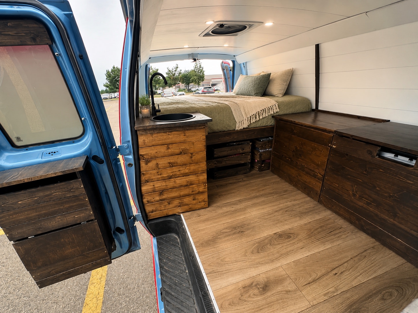 Step into this cozy RV rental campervan interior! Features a bed, sink & ample storage for your van life journey.. Ford E250 Eagle Camper 2012