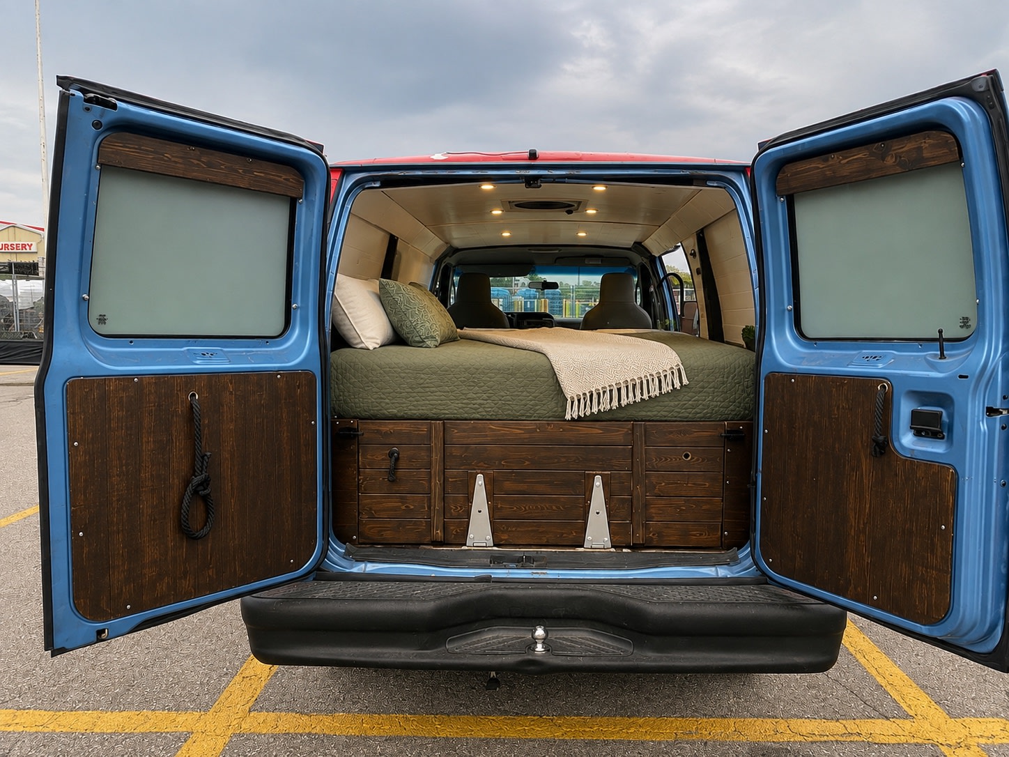 Cozy RV rental camper van with open rear doors revealing a custom bed, wooden storage, and ambient lighting.. Ford E250 Eagle Camper 2012