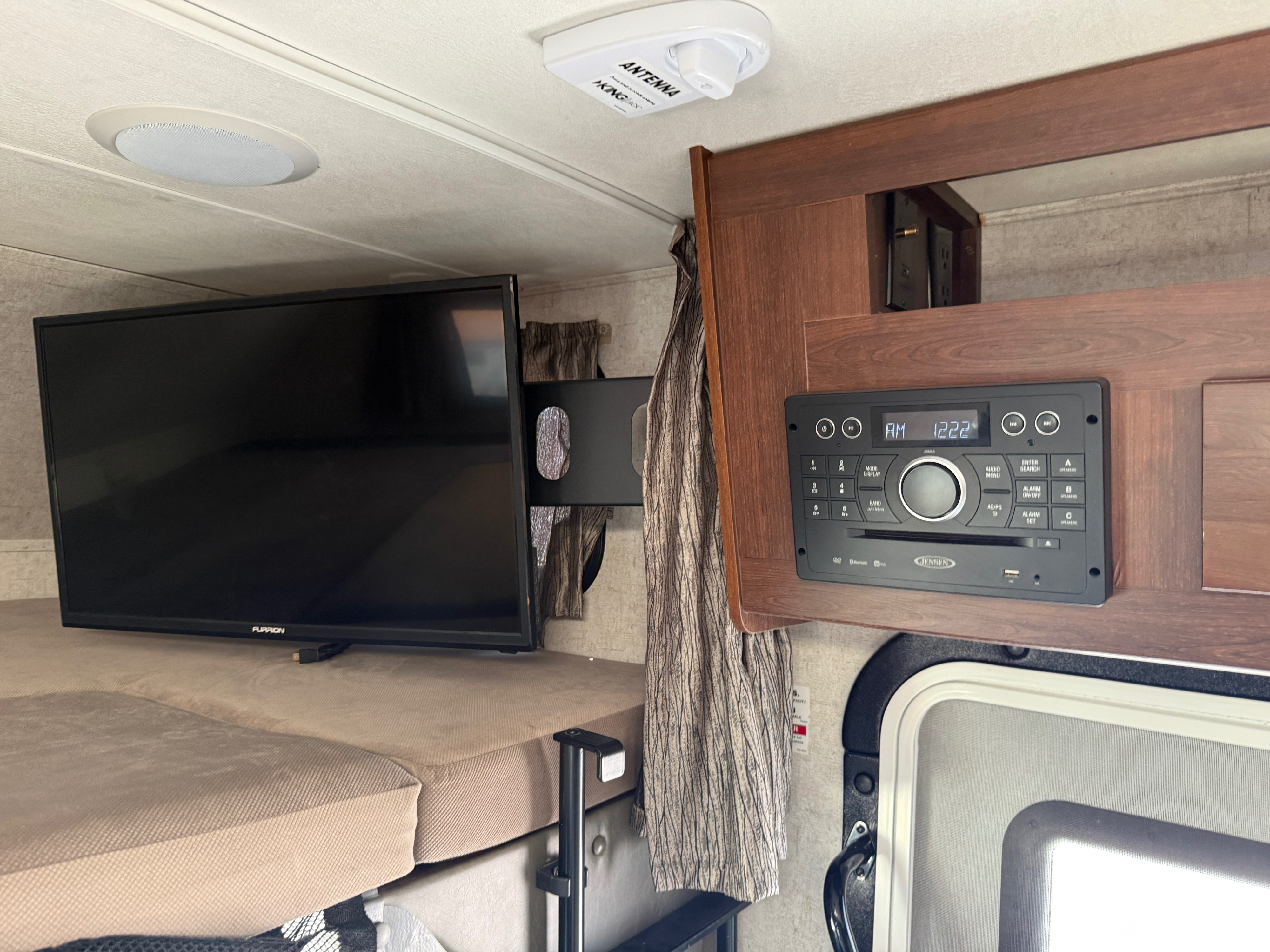 RV rental interior showing a Furrion TV, Jensen stereo, Kingnex antenna, and a cozy bunk area.. Forest River Sunseeker MBS 2018
