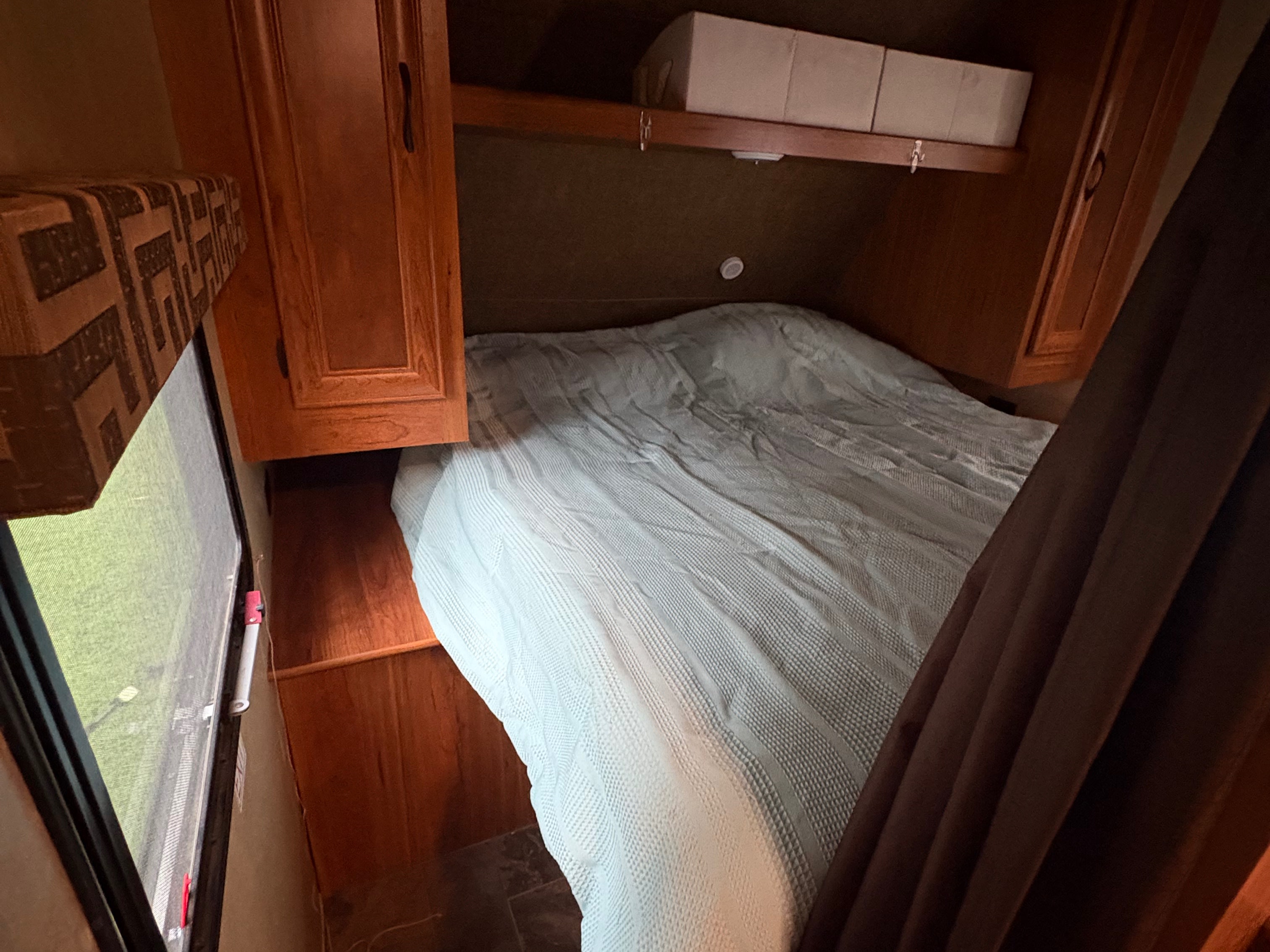 This RV rental offers a cozy bedroom with a comfortable bed, wooden storage, and a window to the outdoors.. Starcraft AR-One Maxx 2016