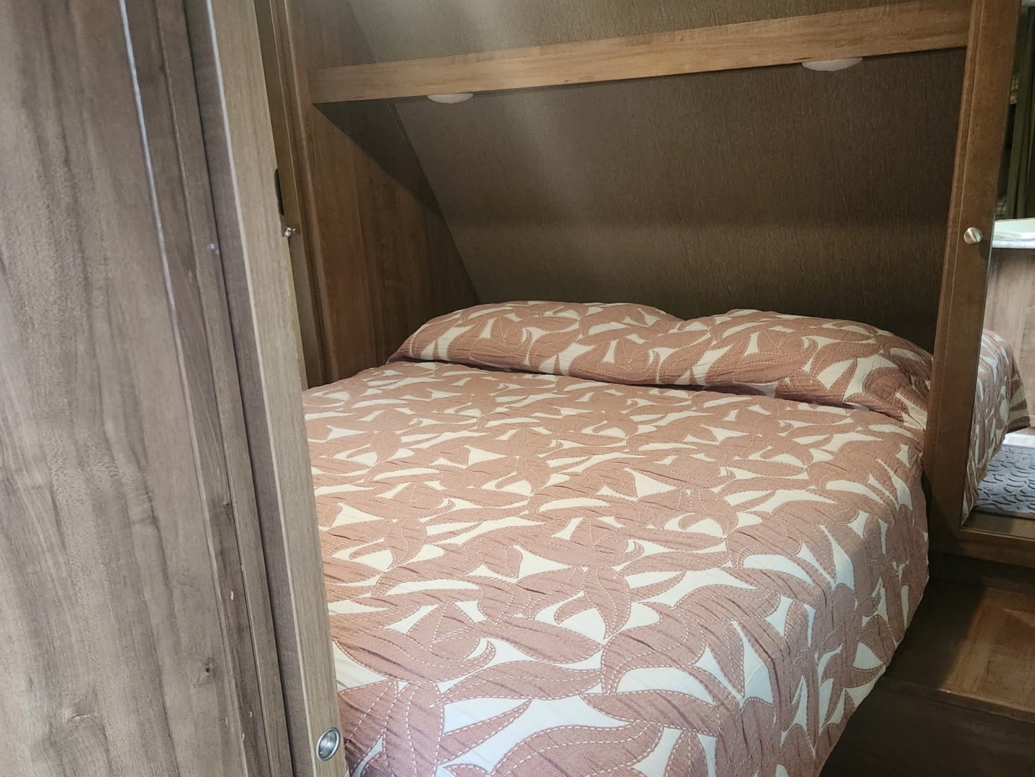 RV rental: Efficient overhead storage featuring a neatly tucked pink patterned cushion, showcasing practical space in a compact interior.. Aspen Trail Aspen Trail Trailer 2018