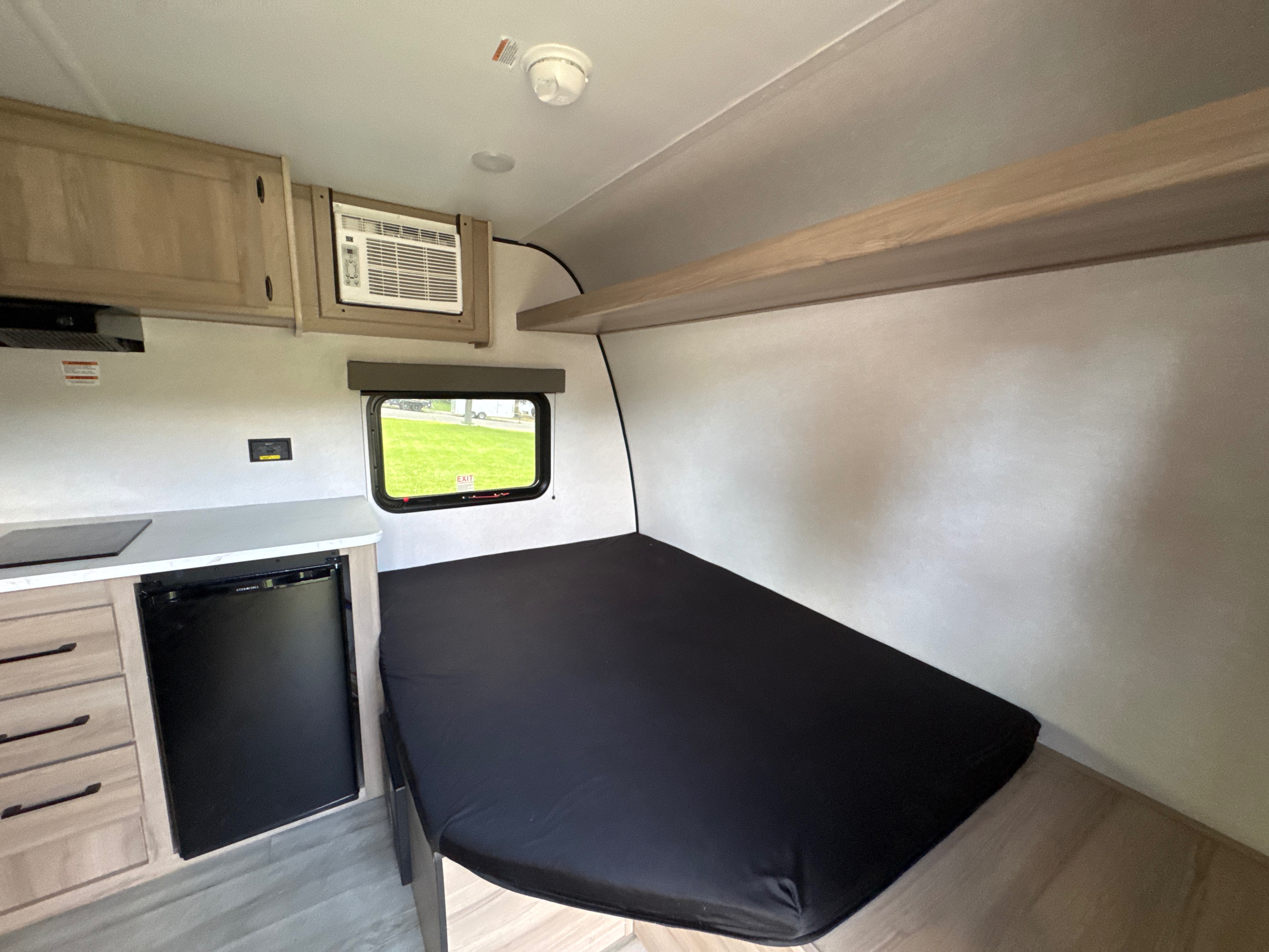 This rv rental's compact interior features a bed, kitchenette with fridge, AC, and window. Ideal for travel.. Keystone RV Coleman 2026