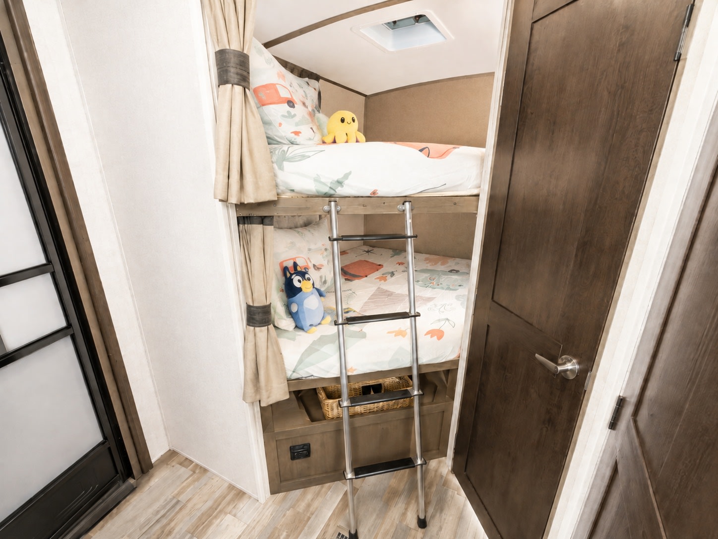 This cozy RV rental features bunk beds with fun bedding and toys, creating a comfortable and inviting sleeping space for kids.. Forest River Surveyor 2018