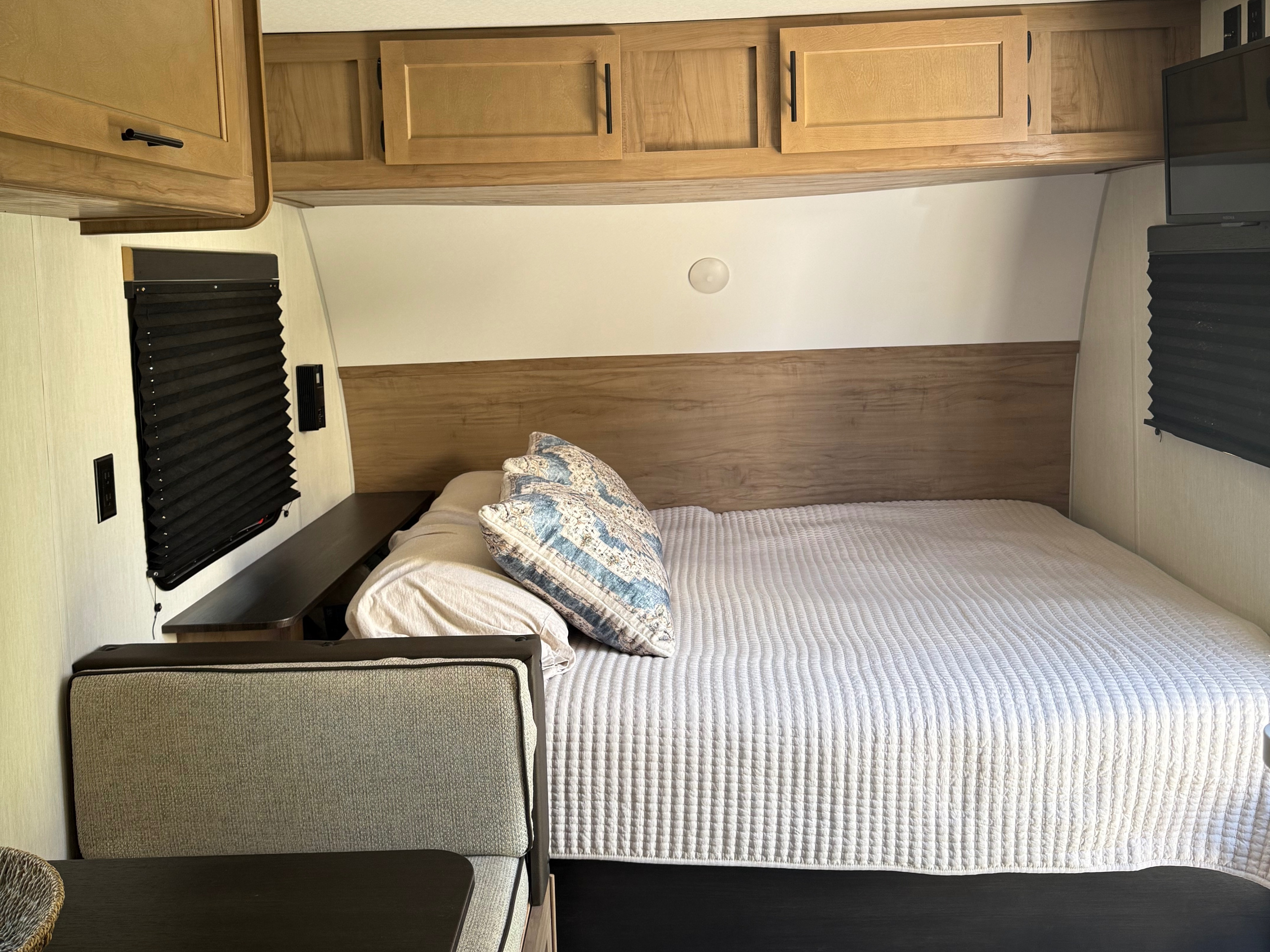 Cozy RV rental bedroom with a large bed, light wood cabinets, and dark window blinds, offering comfortable sleeping space.. Forest River Cherokee Wolf Pup 2025