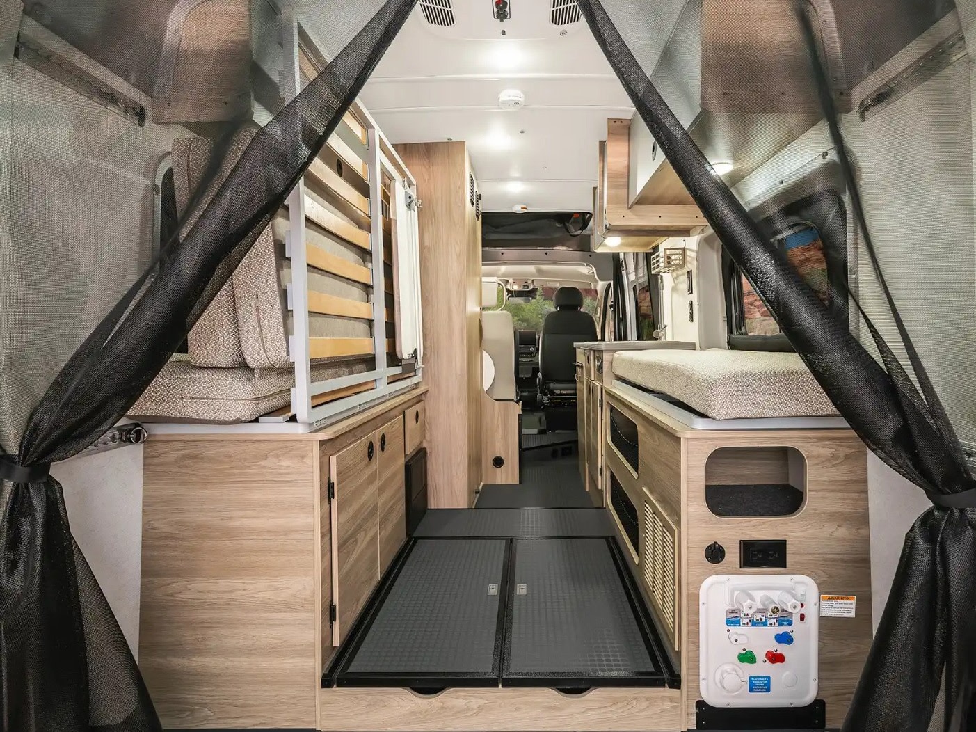 Inside an rv rental camper van: modular wood interior with beds/seating, a central aisle, and bug screen view from the rear.. Winnebago Solis 59PX 2025