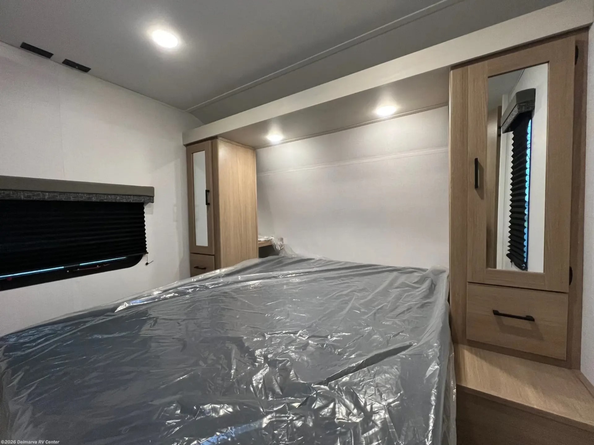 Spacious RV rental bedroom with a covered bed, overhead storage, and window. Ready for your next adventure!. Aspen Trail LE 2026