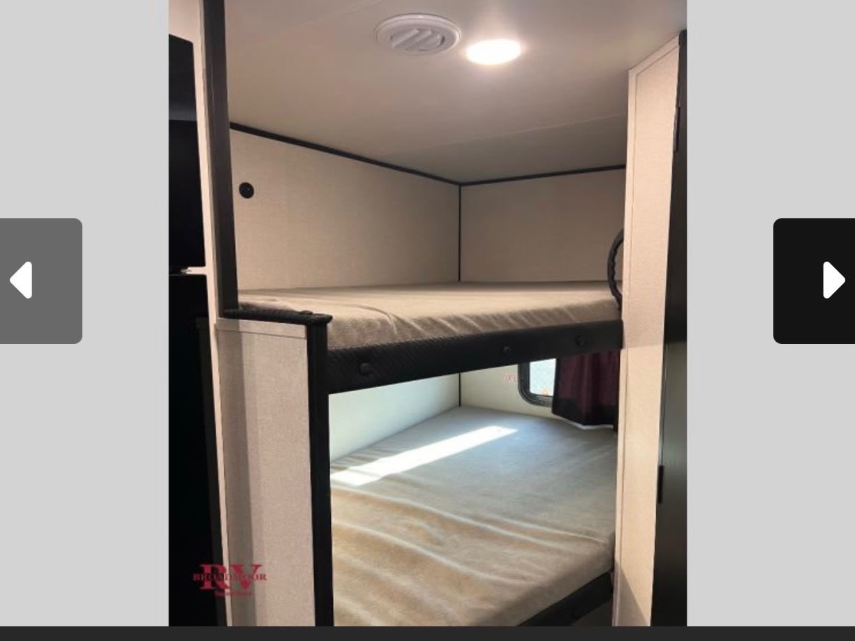 RV rental bunk beds: comfortable sleeping space in an RV, featuring two mattresses, an overhead light, and a vent.. Jayco Jay-flight 2026