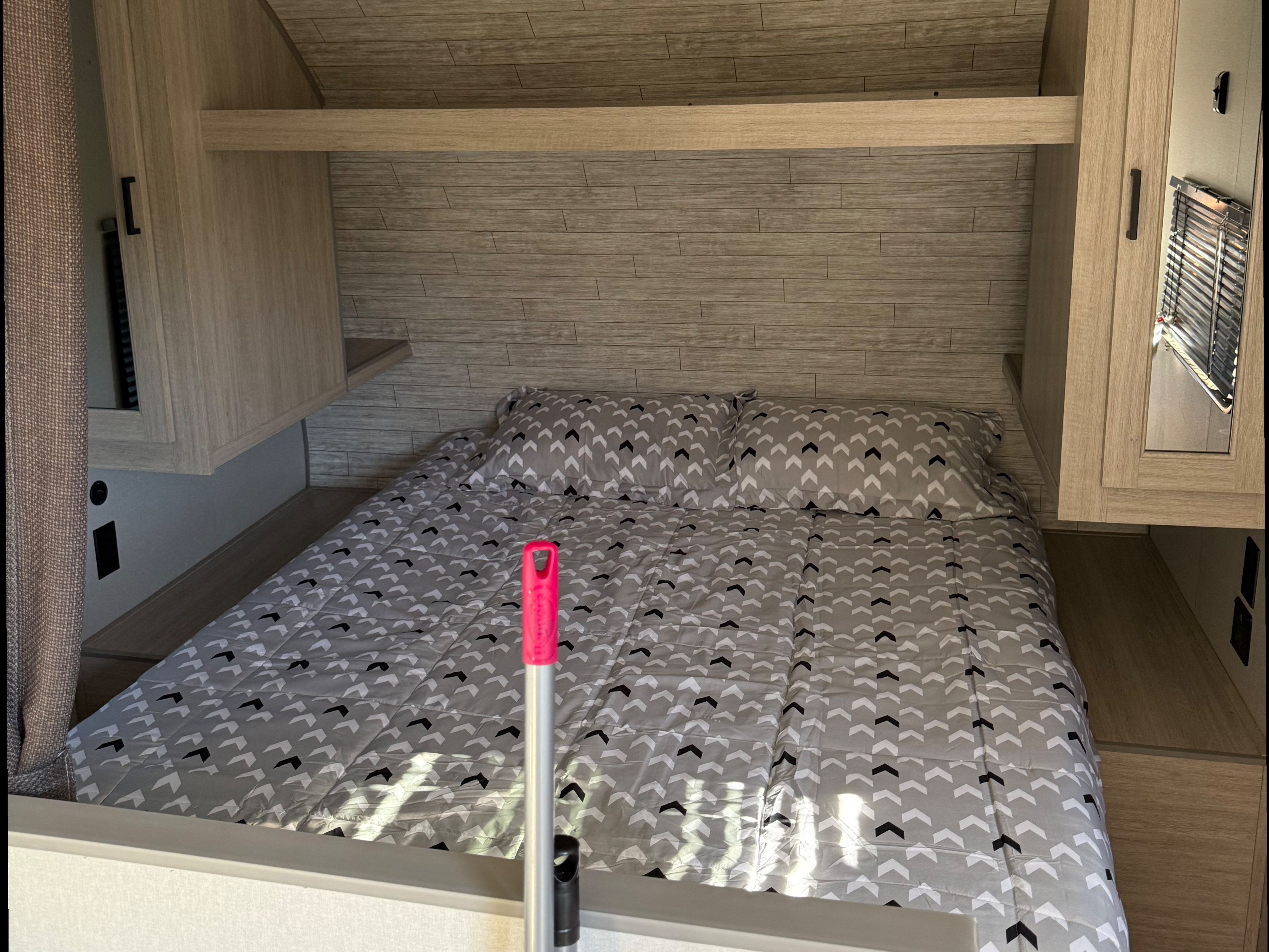Cozy RV rental bedroom: a bed with chevron pattern, light wood walls, and integrated storage units.. Coachmen Catalina 261 bh 2026