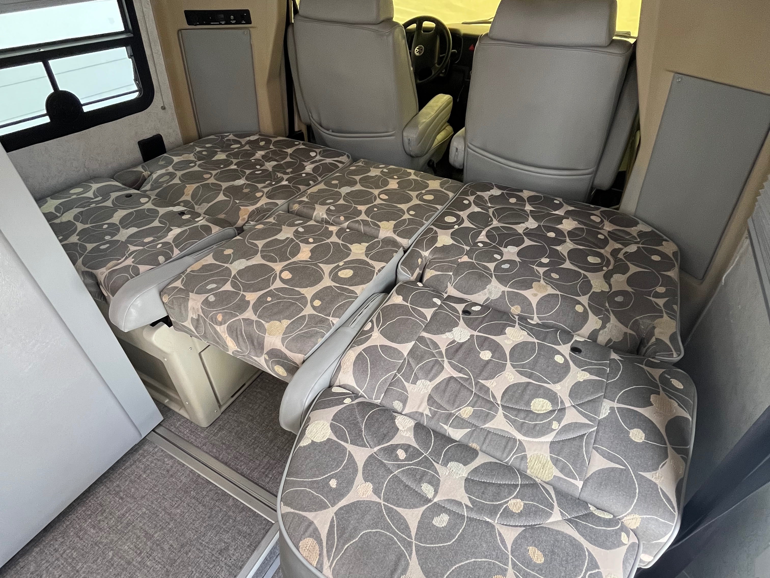 RV rental interior showing versatile seating/bed area with patterned cushions & rotated front seats for lounging.. Eurovan Camper Eurovan Camper Class B 2003