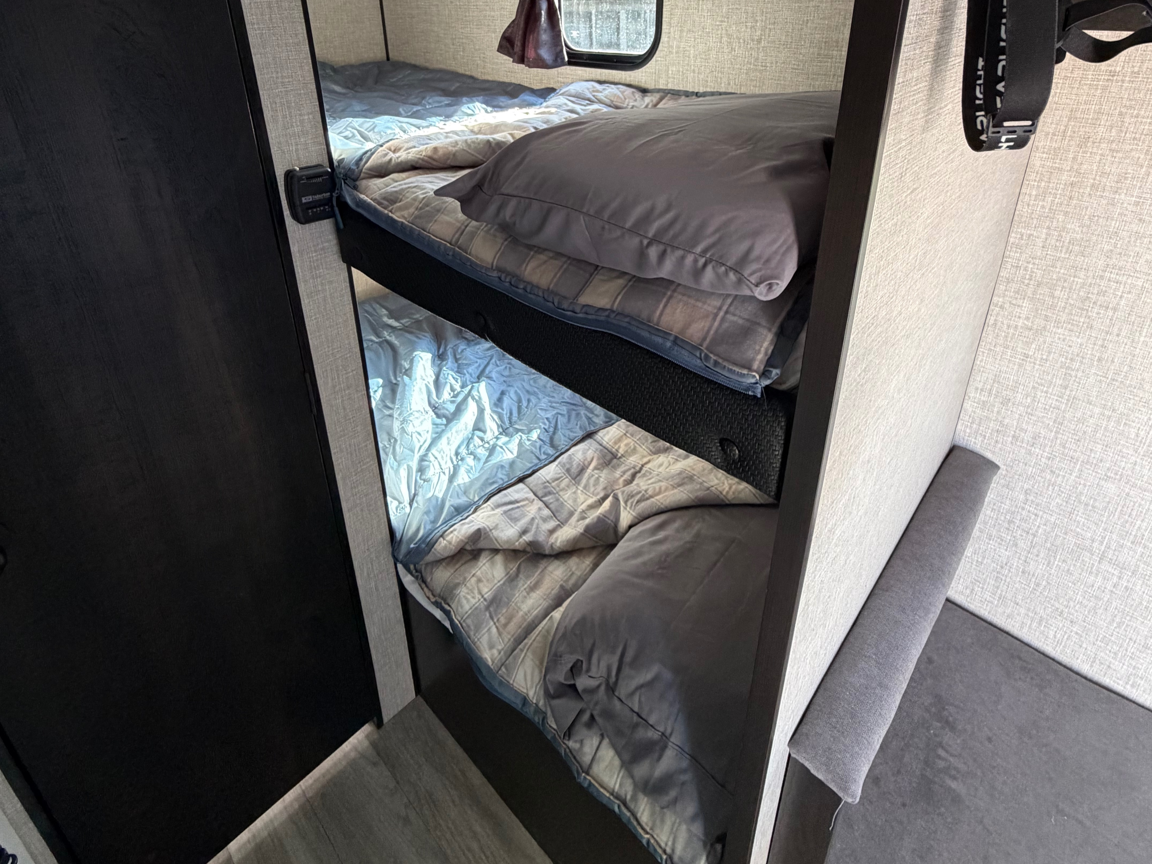Cozy bunk beds with pillows and blankets in an RV rental. Perfect for sleeping in this comfortable camper interior.. Jayco Jay Flight SLX Baja Edition 2023