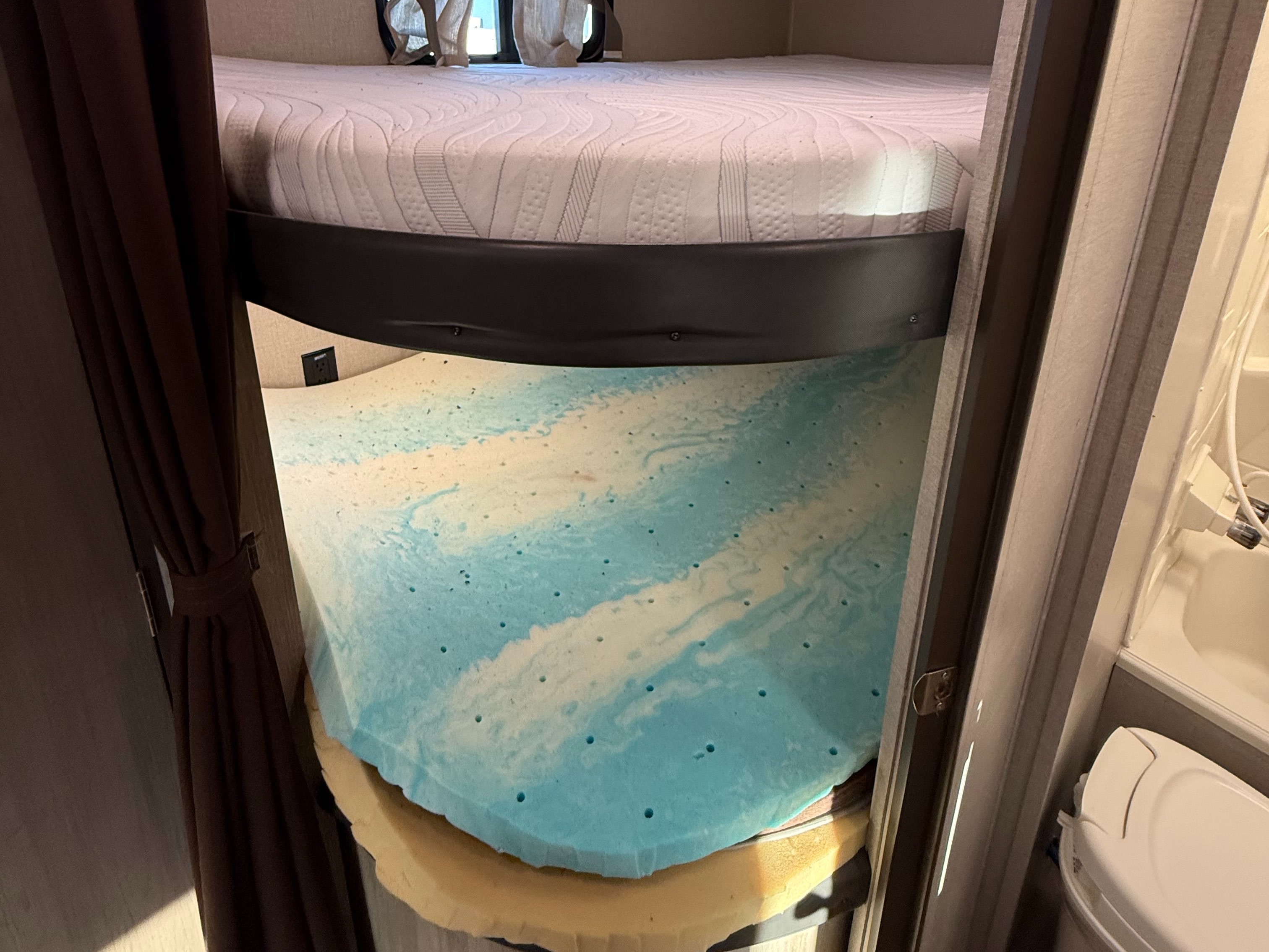 RV rental bunk bed with mattress lifted, showing a blue cool-gel memory foam topper over a yellow base foam.. Coachmen Catalina Summit Series 261BHS 2020