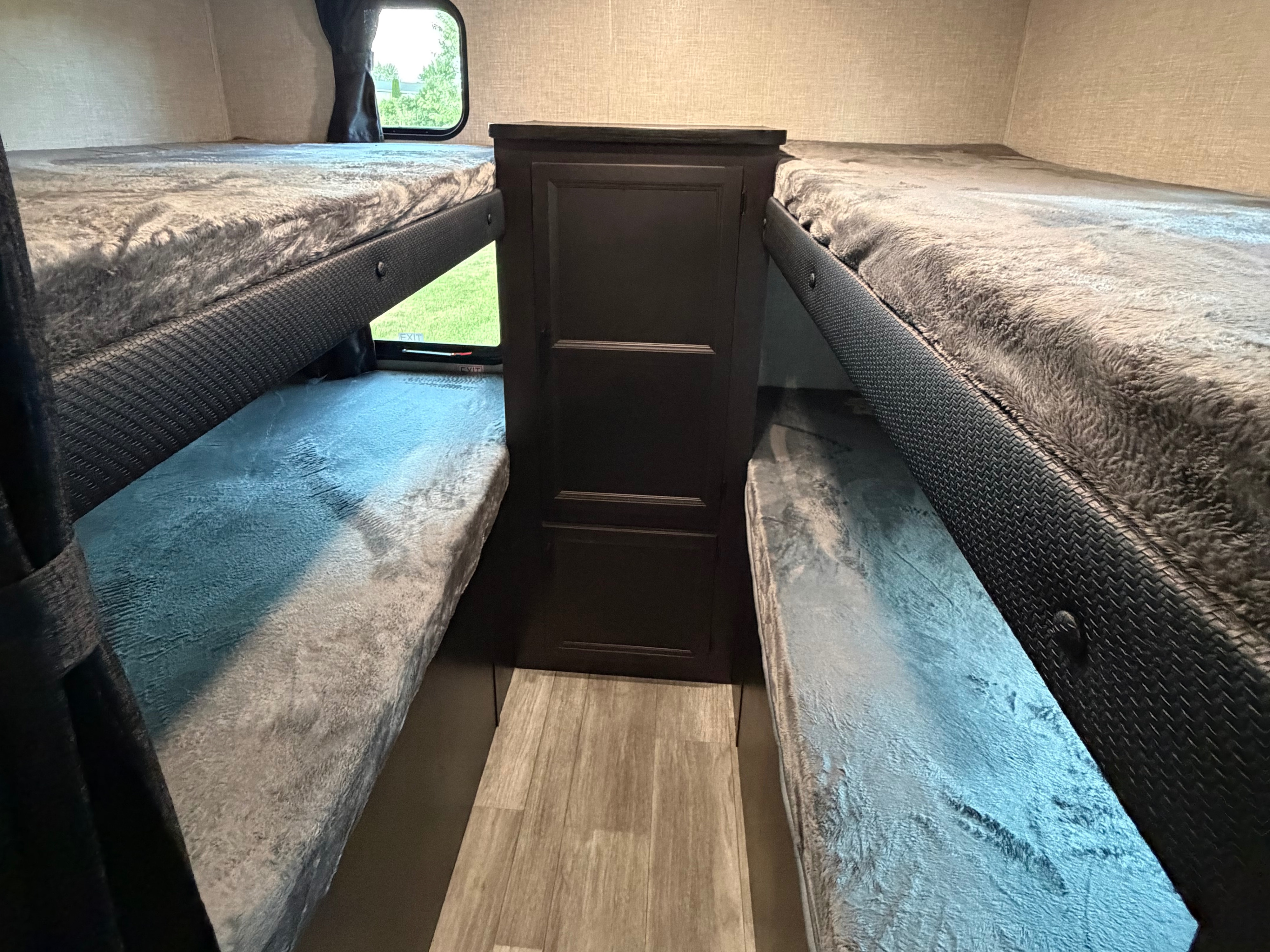 Cozy bunk beds with plush blankets and a central storage cabinet in this RV rental.. Jayco Jay Flight 2023