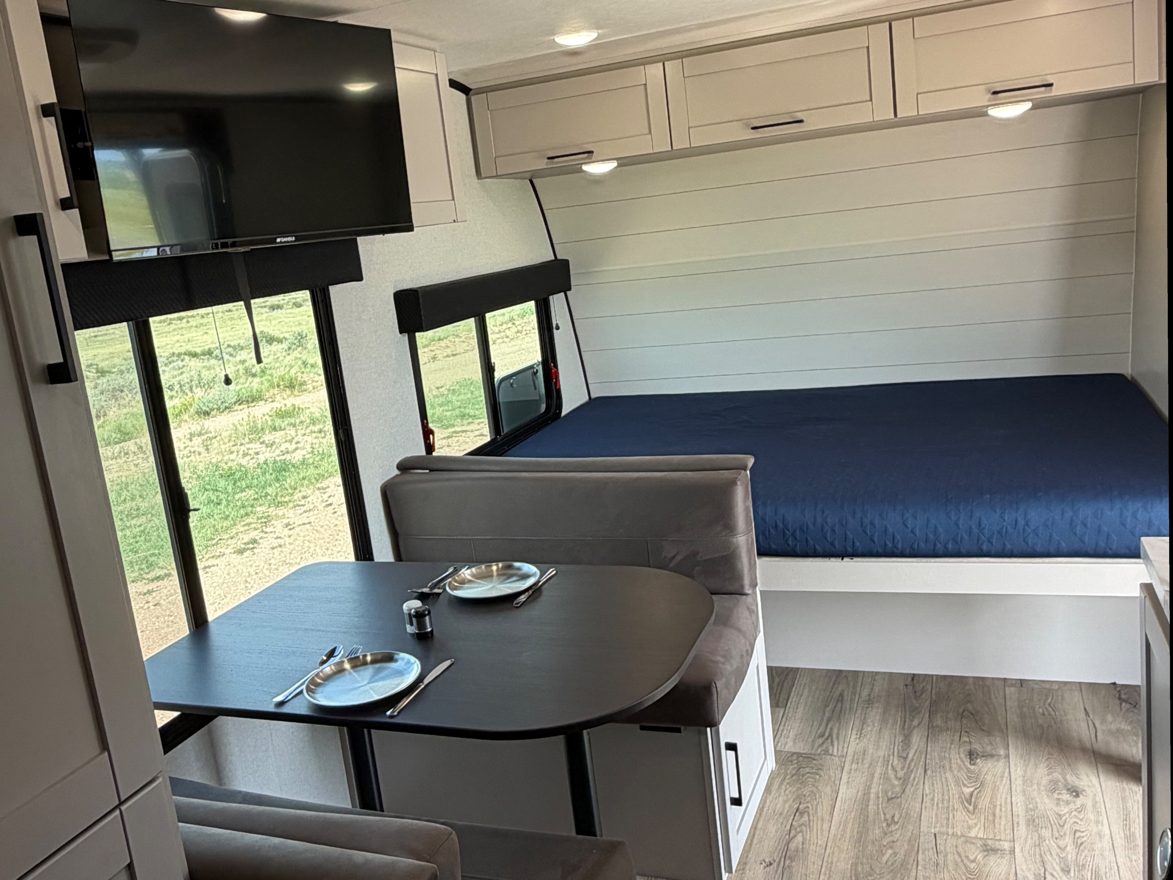 Modern RV rental interior featuring a dinette, bed, TV, and overhead storage, perfect for compact travel living.. Jayco Jay Feather Air 2026