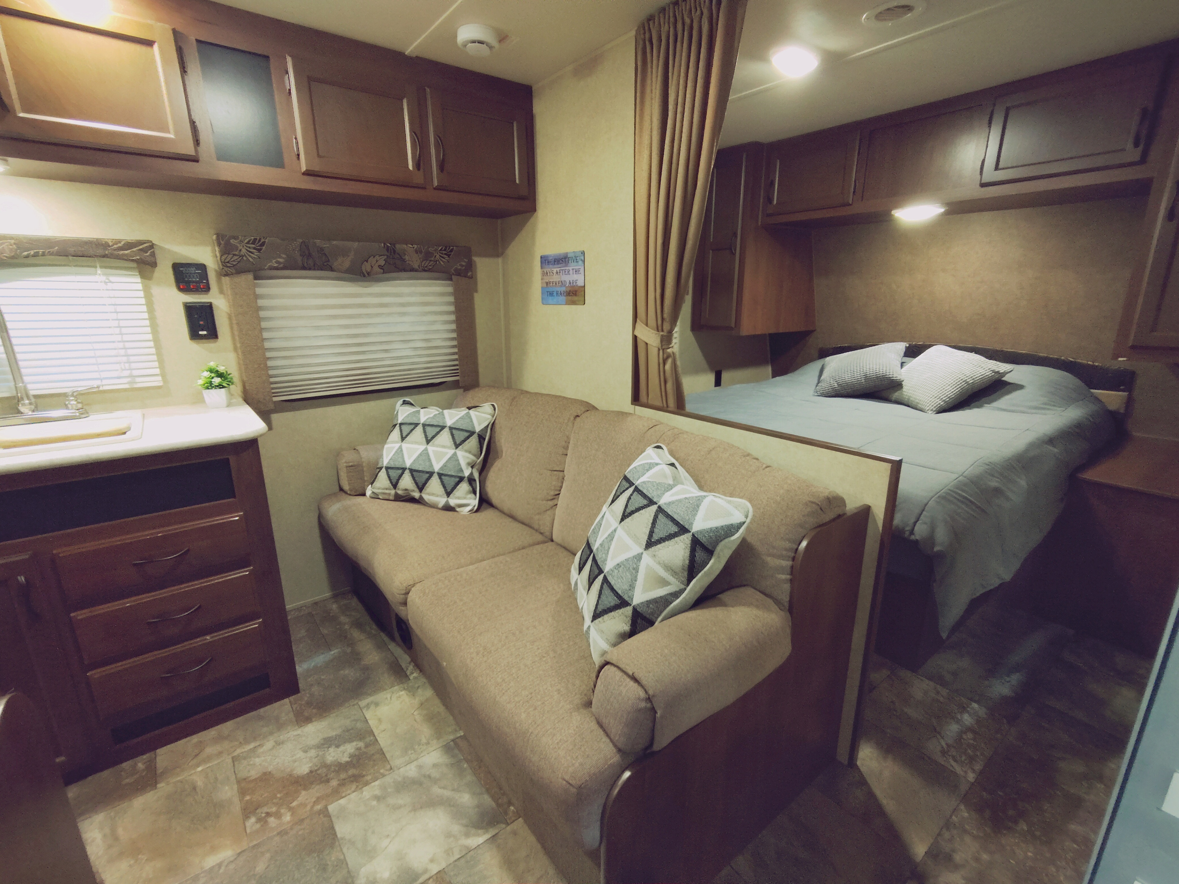 RV rental interior with a welcoming living room, kitchen counter, overhead cabinets, and a comfortable bed in the back.. Jayco Jay Flight Swift 2014