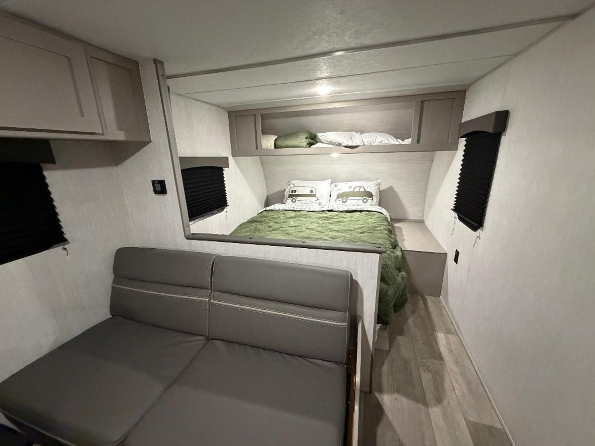 Comfortable RV rental interior: queen bed, sofa, and overhead storage. Ideal for your next adventure.. Forest River Viking 5K 2025