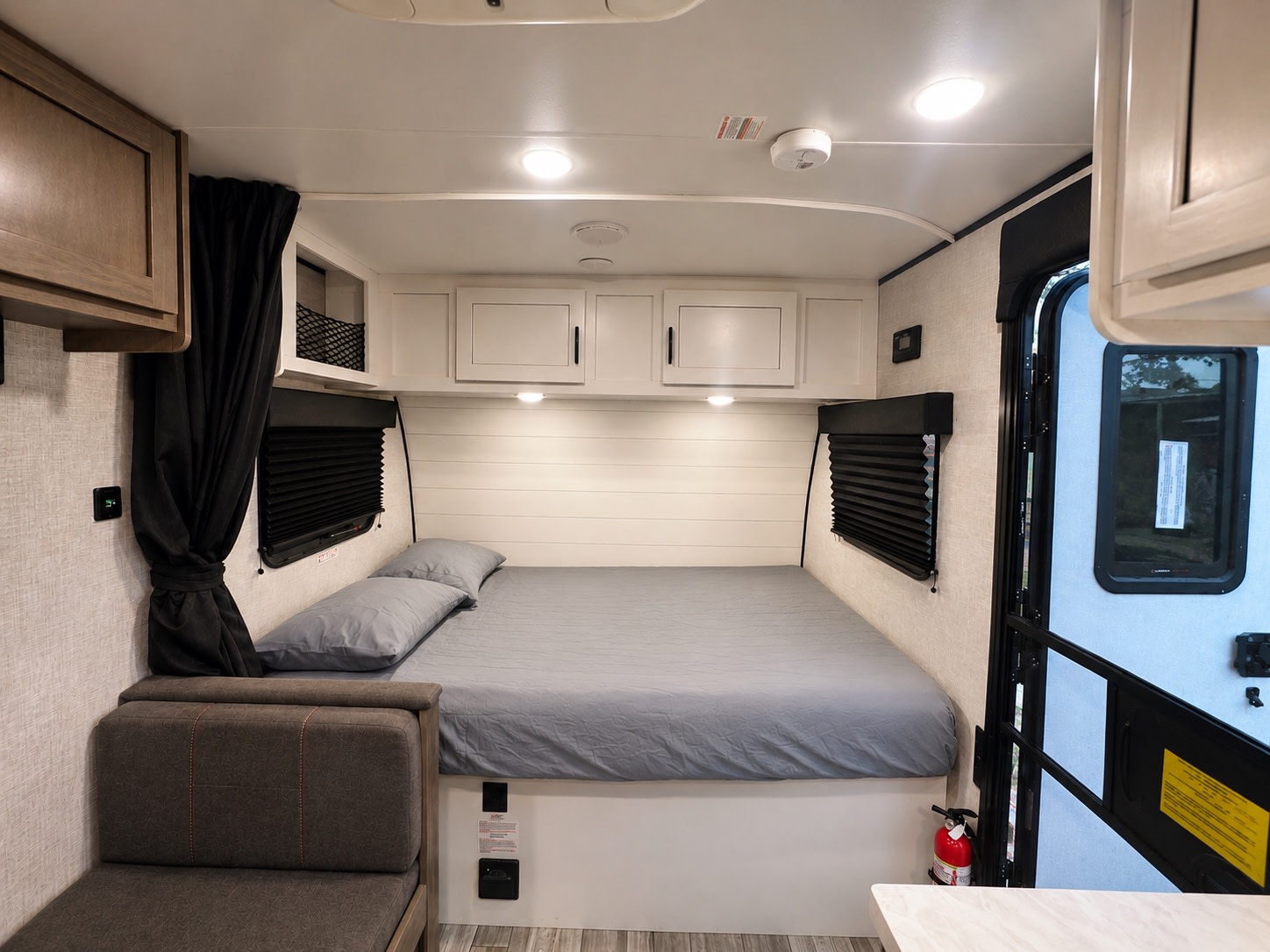Clean & modern RV rental bedroom featuring a comfy bed, small sofa, and ample storage. Your next adventure awaits!. Jayco Jay Flight SLX 2024